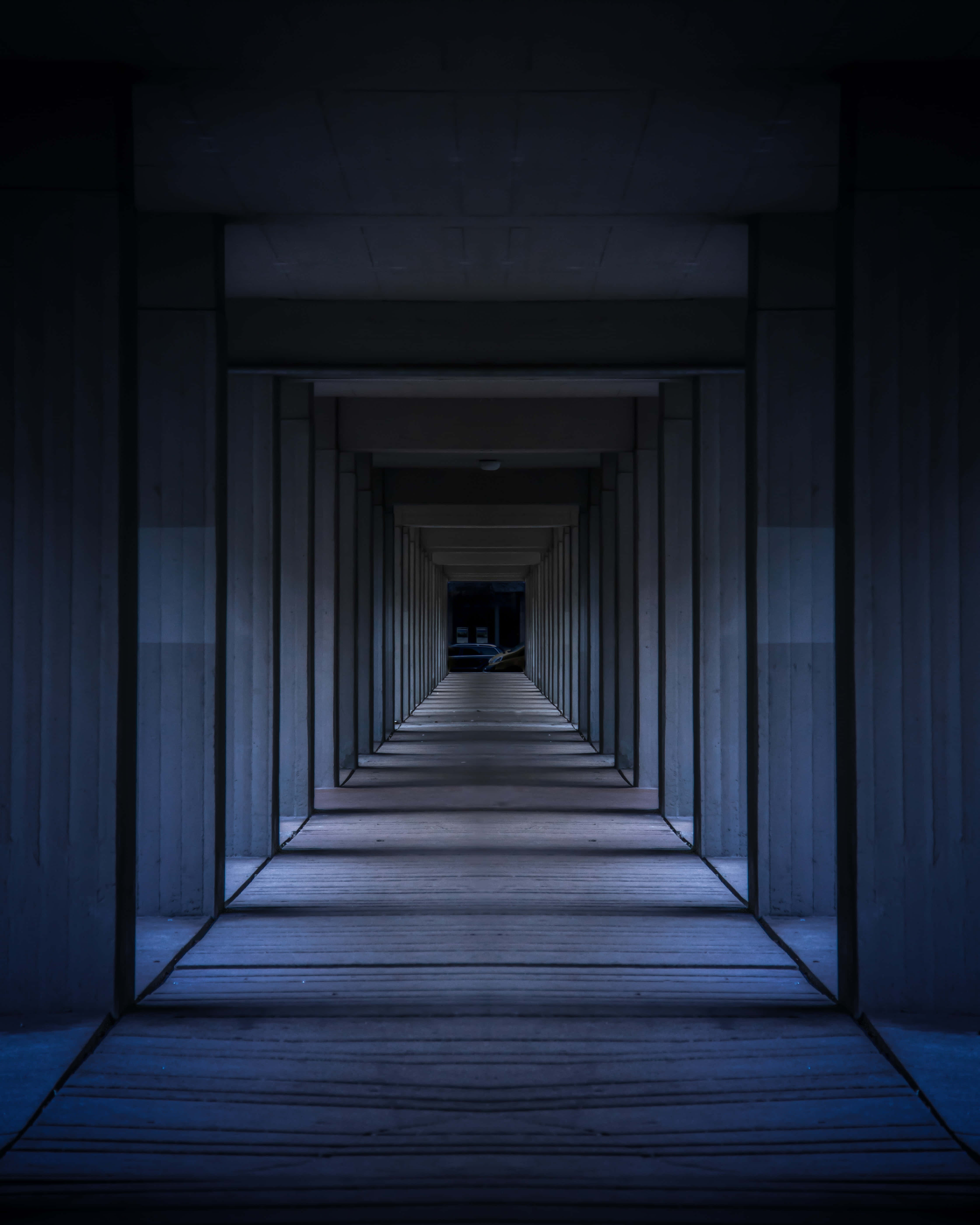 Dark Room 桌布 壁紙 — 一條長長的、燈光昏暗的木製碼頭隧道，逐漸消失在黑暗中，遠端有微弱的光芒。