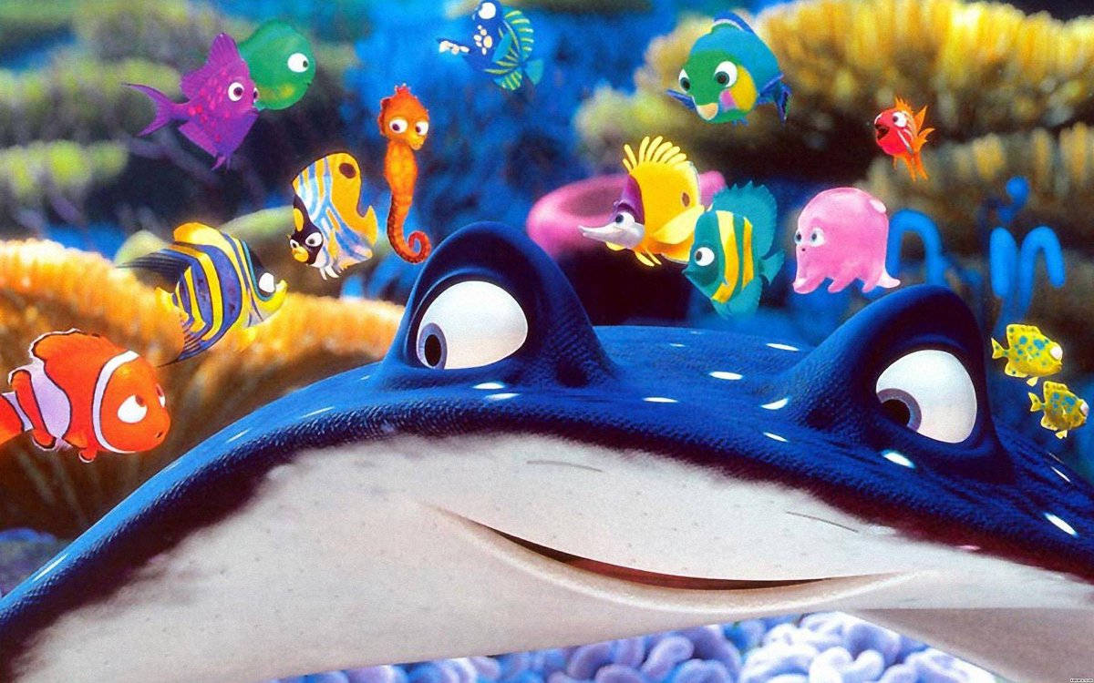 nemo 桌布 壁紙 — 一條開心的藍色魔鬼魚溫暖地微笑，色彩繽紛的卡通魚和一條海馬在充滿活力的珊瑚礁中頑皮地游來游去。
