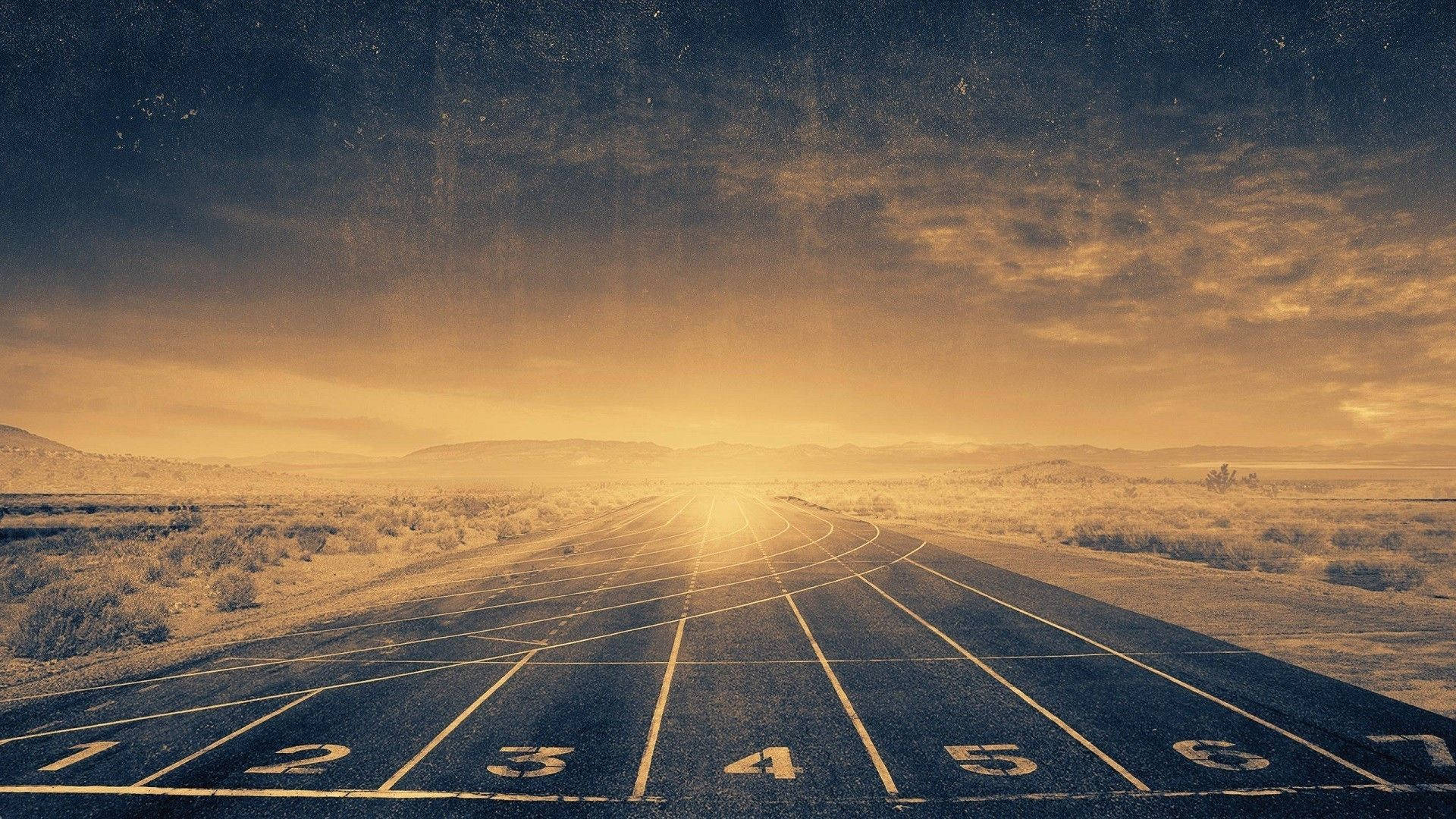 Runway 桌布 壁紙 — 一條陽光普照的跑道伸入廣闊的沙漠景觀，上方是戲劇性的金色天空。