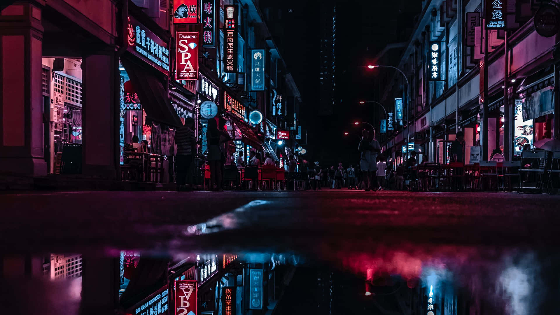 霓虹招牌倒映在繁忙城市街道的雨水坑中，夜晚時分。 — 寬螢幕動態圖片 壁紙
