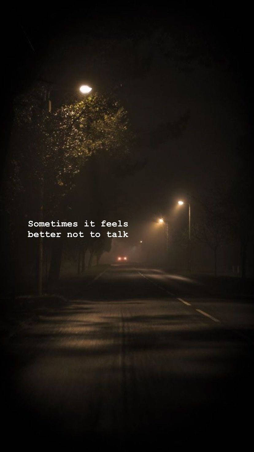 一條霧氣瀰漫的夜晚街道，有路燈和一輛汽車從遠處靠近。 — 深色引言 壁紙