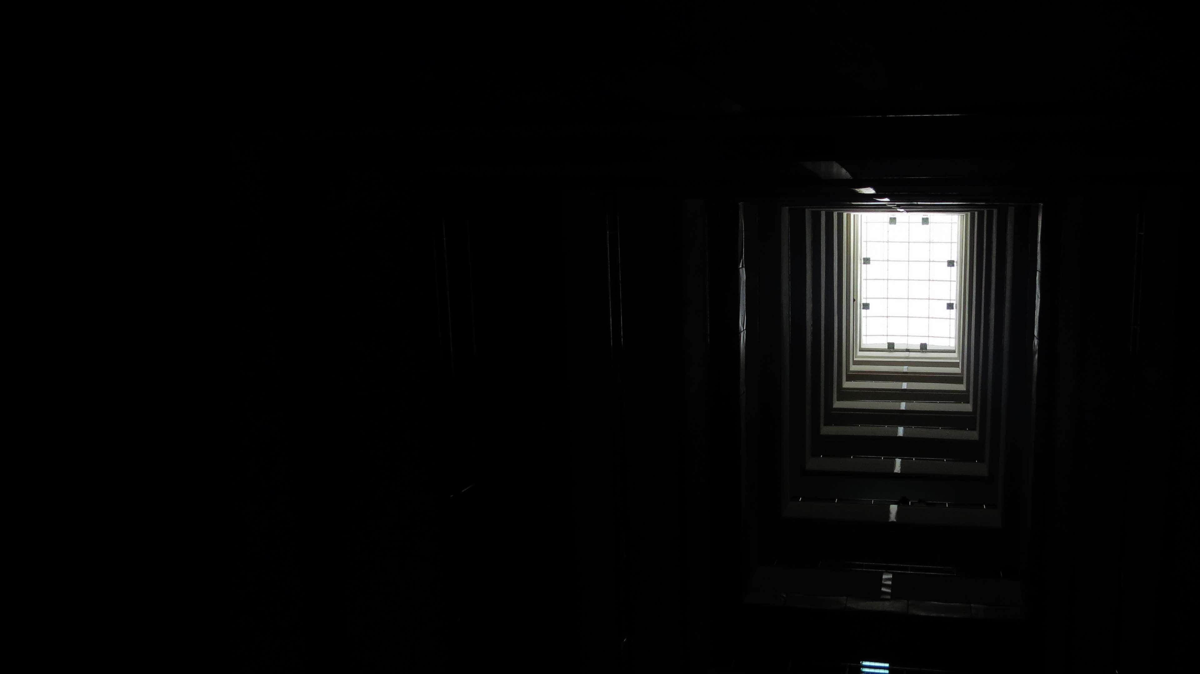 Dark Web 桌布 壁紙 — 一條黑暗走廊中，一扇明亮的窗戶被深邃的陰影框住，形成強烈的對比。