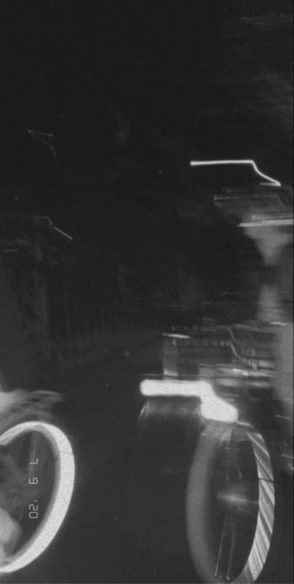 Black Blur 桌布 壁紙 — 一條黑暗道路上，汽車發光頭燈和車輪的黑白動態模糊夜景。
