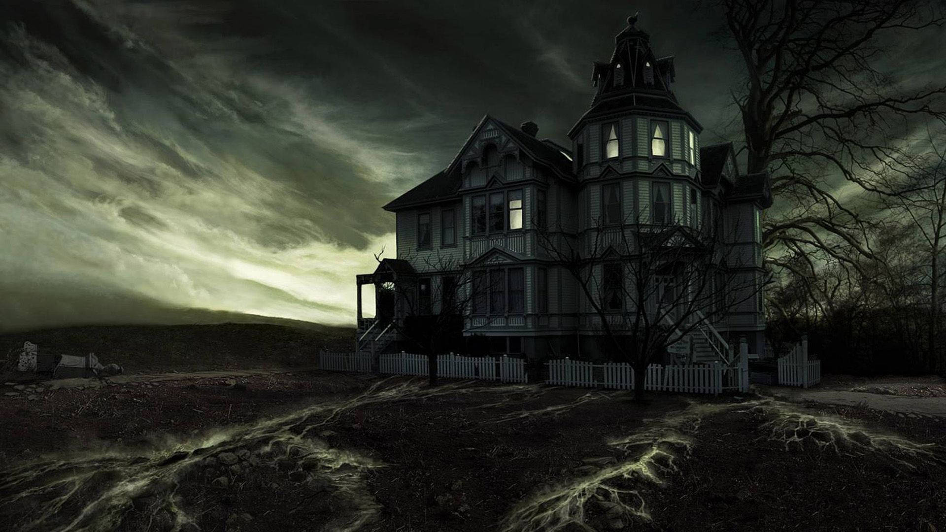 Monster House 桌布 壁紙 — 一棟維多利亞式鬼屋，窗戶發光，孤立地矗立在暴風雨般的綠灰色天空下，周圍是光禿禿的樹木。