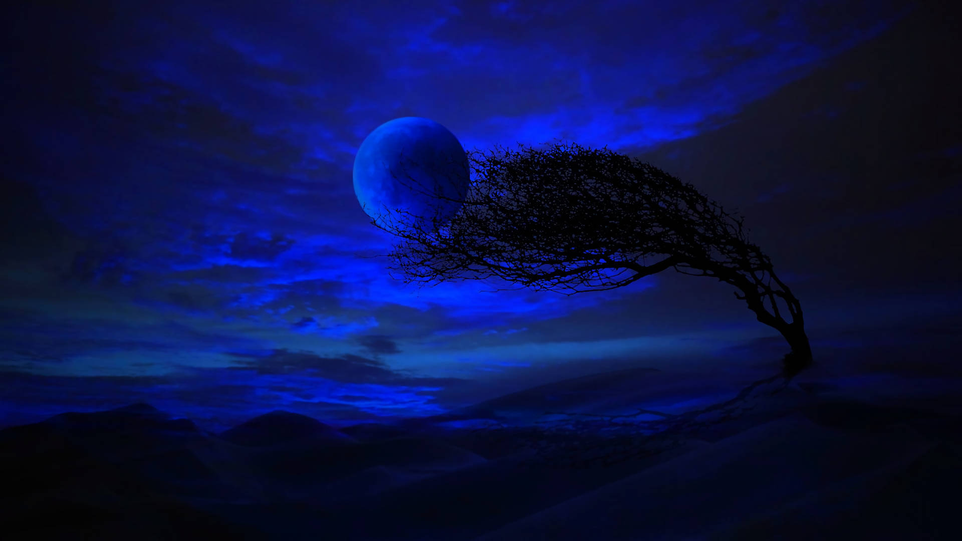 HD Moon 桌布 壁紙 — 一棵孤獨扭曲的樹在廣闊的藍色夜空下形成剪影，一輪發光的月亮在遙遠的山丘上灑下空靈的光芒。