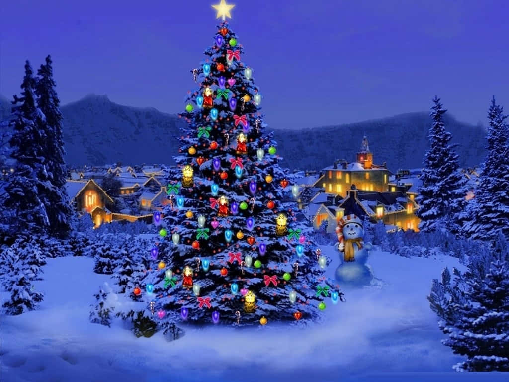 Aesthetic Christmas Tree 桌布 壁紙 — 一棵明亮照明的聖誕樹，裝飾著色彩繽紛的飾品和一顆星星，矗立在夜晚的雪村中，背景是白雪覆蓋的房屋和山脈。
