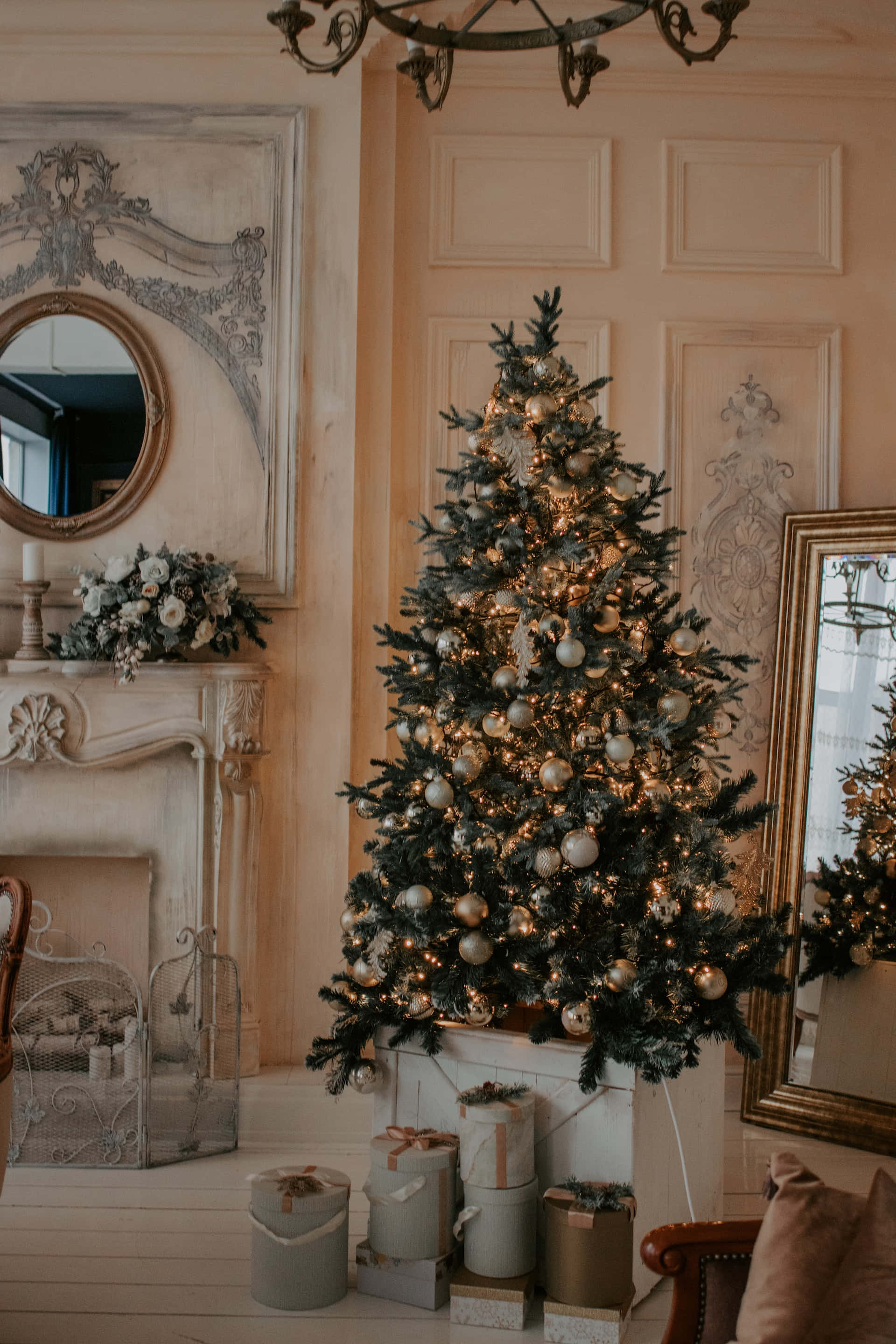 Aesthetic Christmas Tree 桌布 壁紙 — 一棵植絨聖誕樹，飾有金色和銀色裝飾品及溫暖燈光，優雅地矗立在復古風格的客廳中。