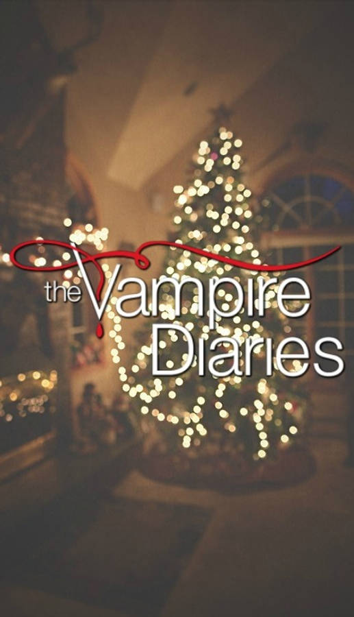 Vampire Diaries 桌布 壁紙 — 一棵溫暖照明的聖誕樹，帶有發光的燈串，站在標題「The Vampire Diaries」後面，在舒適的室內環境中。