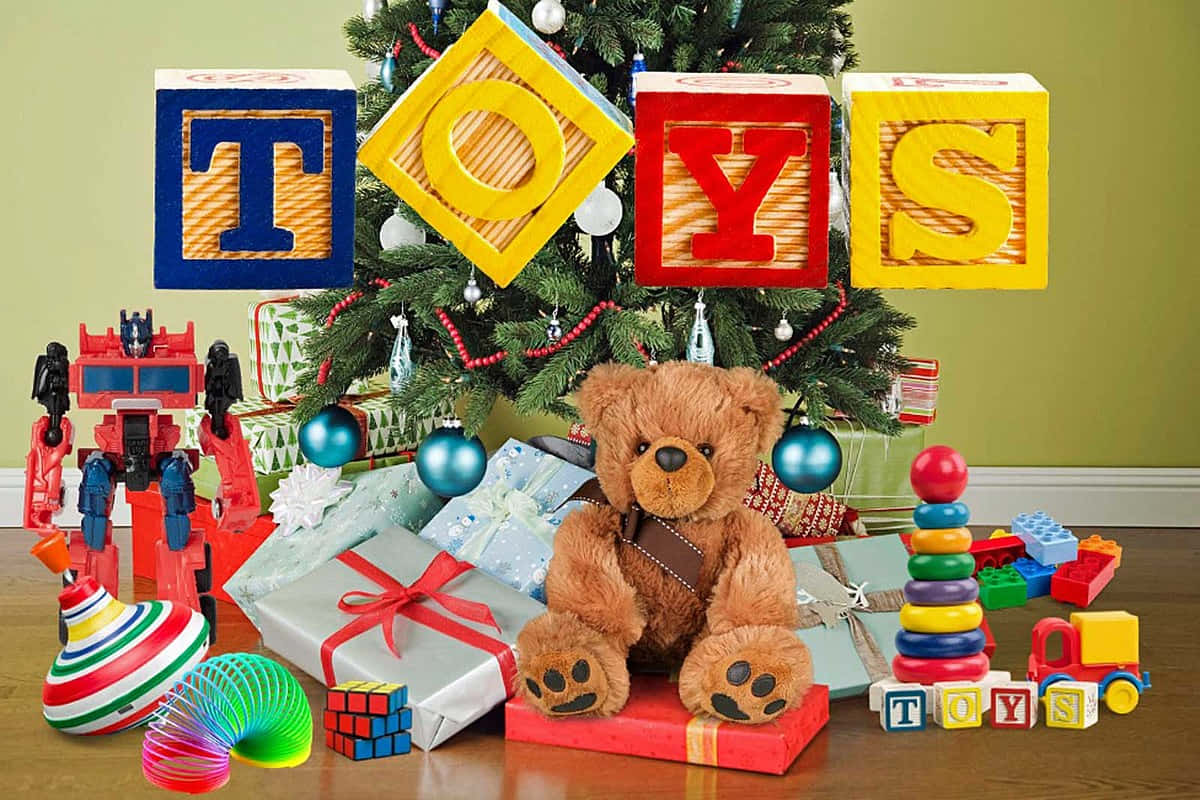 toys 桌布 壁紙 — 一棵節日聖誕樹，周圍環繞著色彩繽紛的玩具禮物和一隻毛絨泰迪熊，在溫暖的節日燈光下。