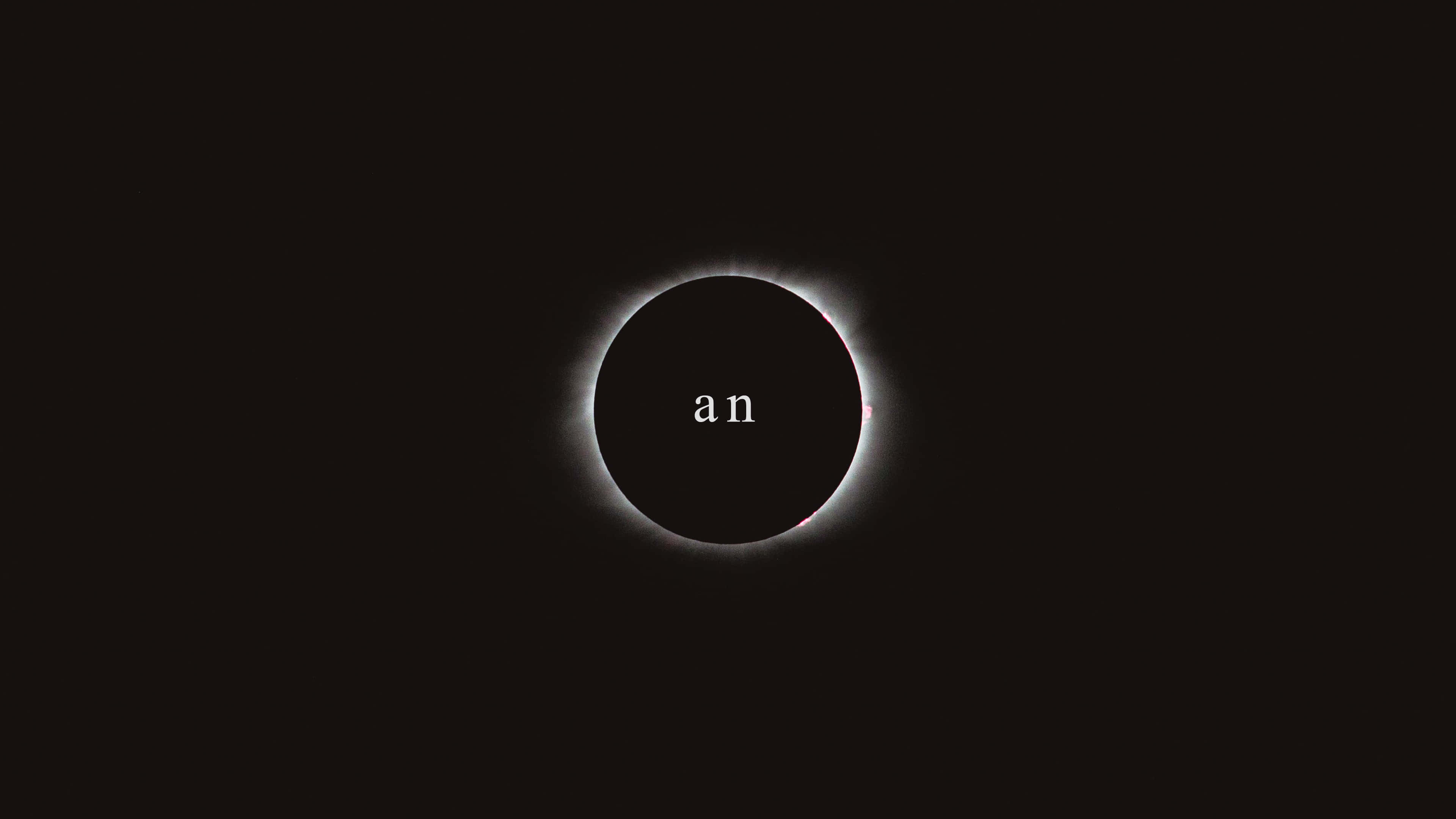 Typography 桌布 壁紙 — 一次日全食，在黑色的天空中，暗淡的日冕中央有「an」這個字。