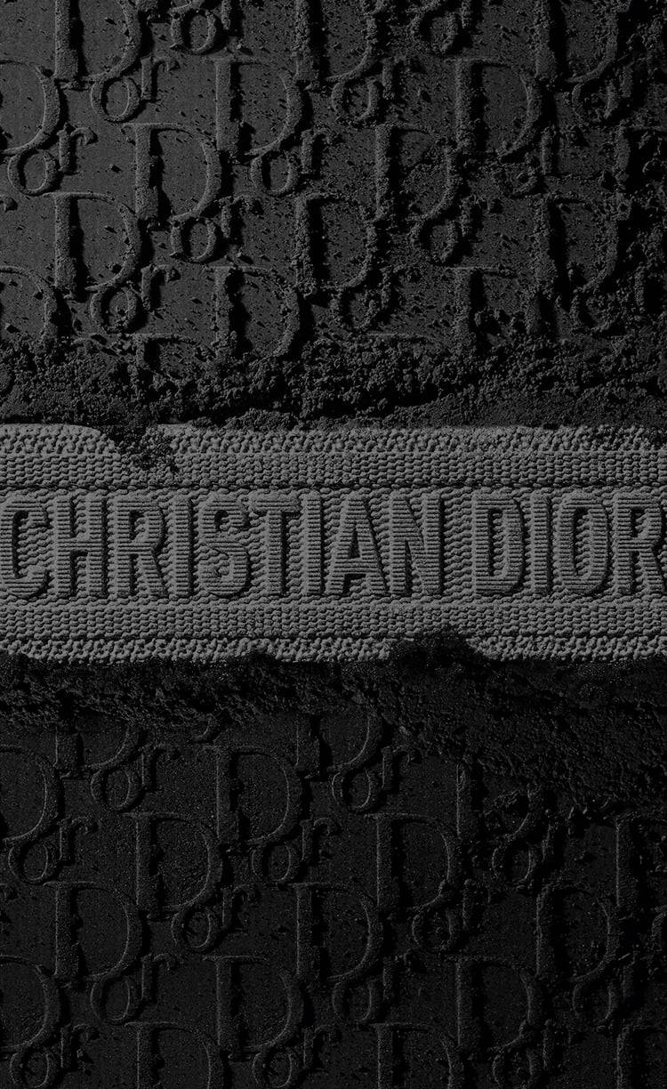 壓花 Christian Dior 標誌圖案在紋理黑色布料上的特寫。 — Dior 動態 壁紙