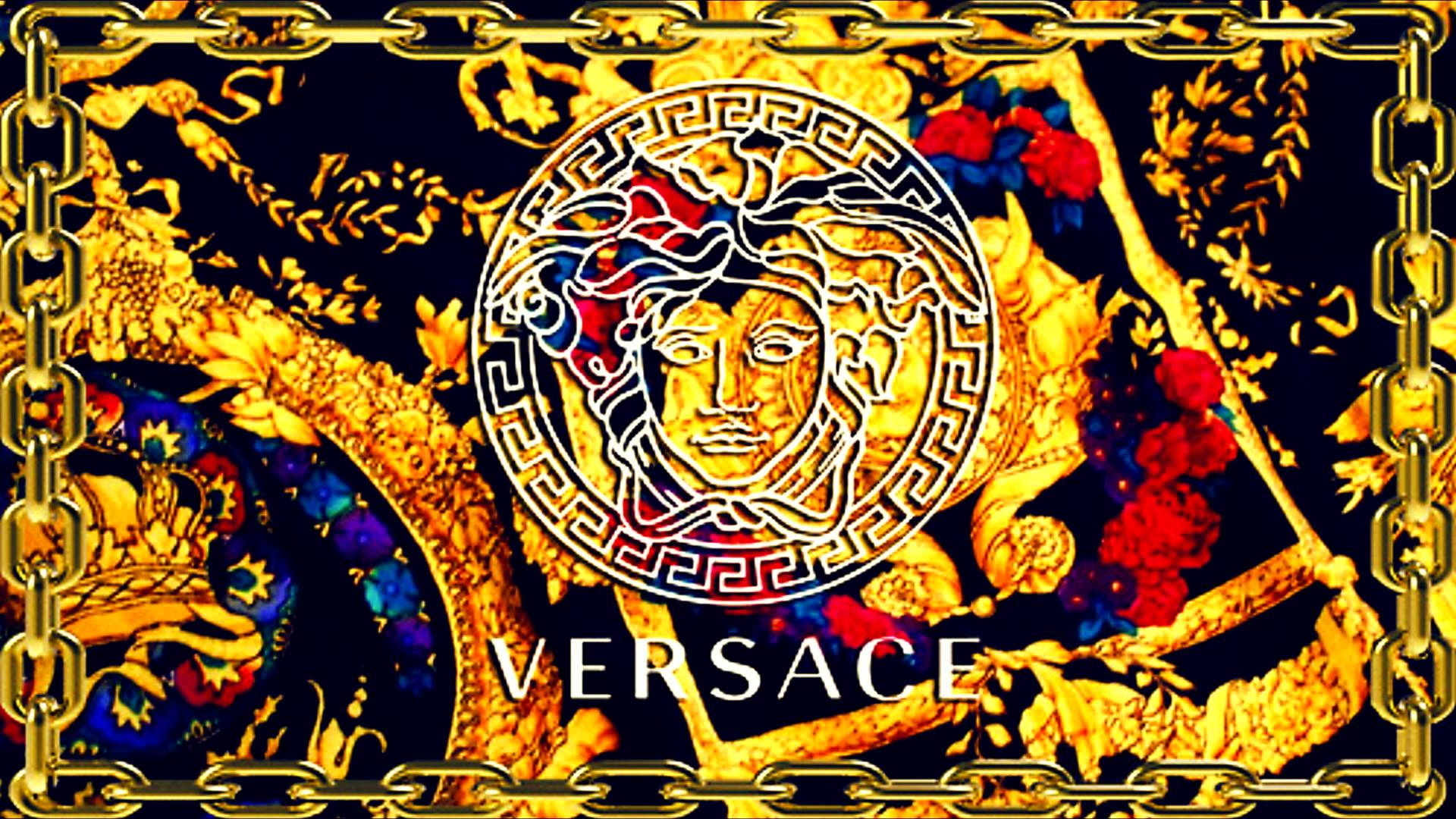 Cool Logo 桌布 壁紙 — 一款奢華的Versace壁紙，在深色背景上展示金色美杜莎頭像標誌，周圍環繞著華麗的鏈條和花卉圖案。