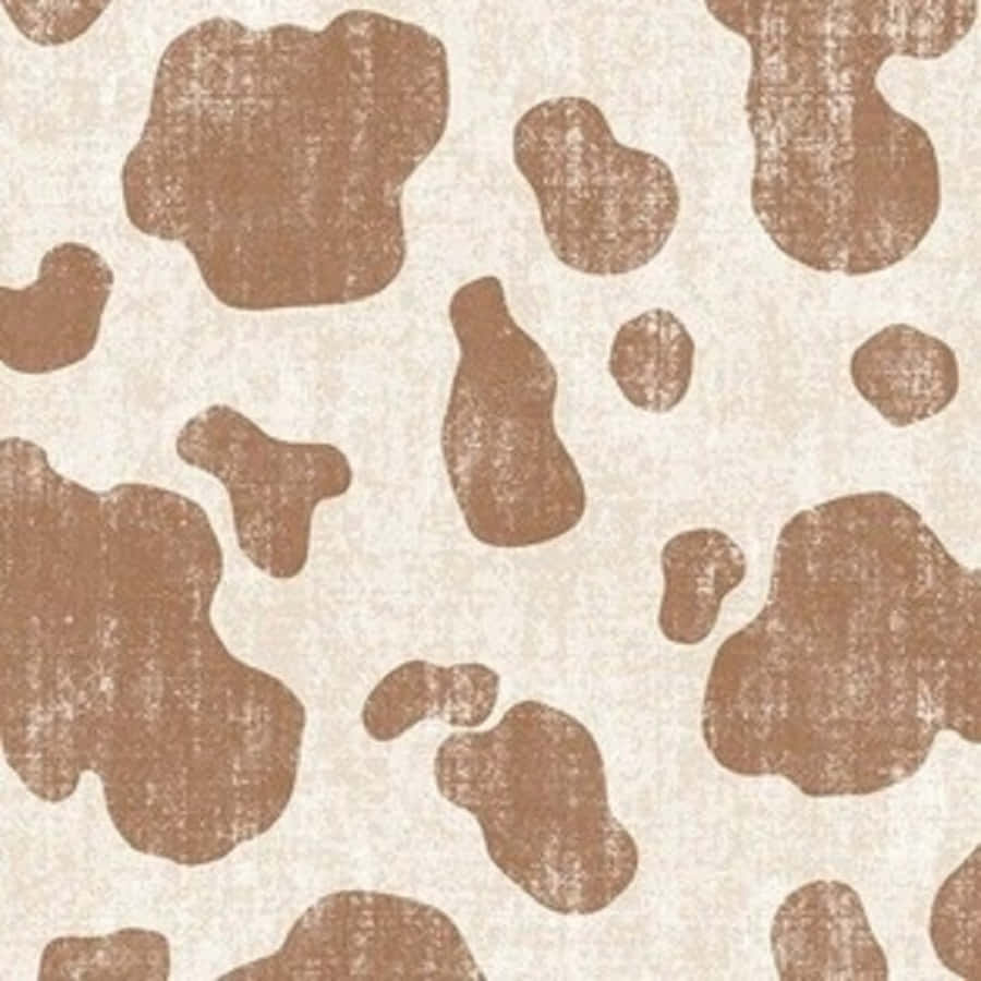 Brown Cow Print 桌布 壁紙 — 一款帶有紋理的壁紙，在奶油色背景上呈現不規則的棕色斑點，模仿牛皮。