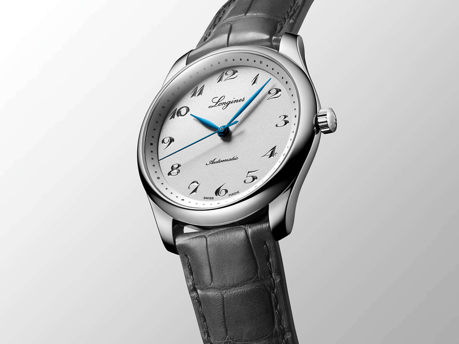 Clock 桌布 壁紙 — 一款時尚的銀色 Longines 手錶，配備藍色指針和深色皮革錶帶，背景為柔和漸變色。