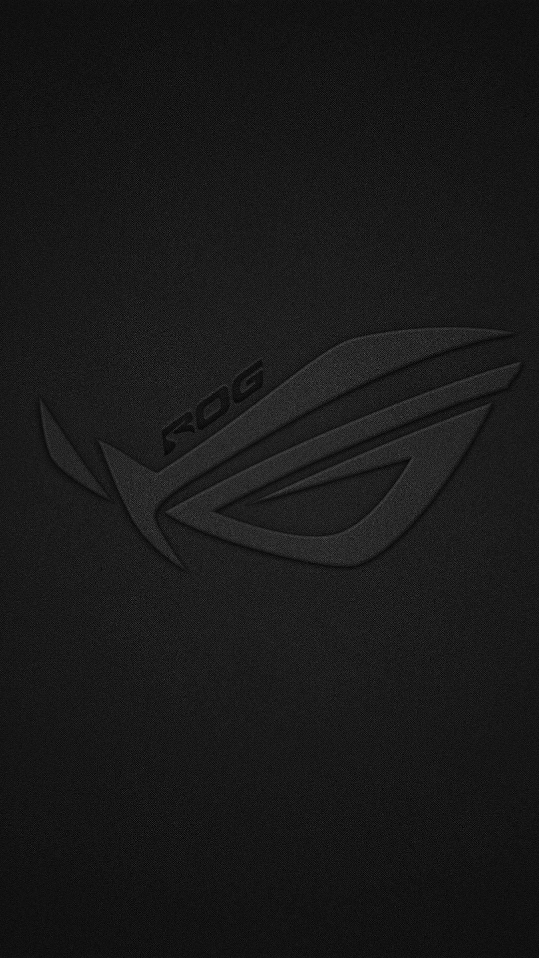 帶有紋理的黑色桌布，壓印有 ROG 遊戲標誌。 — 華碩 ROG 壁紙
