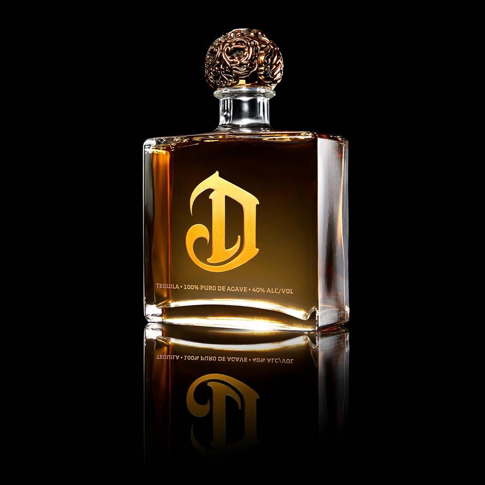 bottle 桌布 壁紙 — 一款豪華龍舌蘭酒瓶，帶有金色「D」標誌和華麗瓶蓋，在黑色背景和反光表面上閃耀。