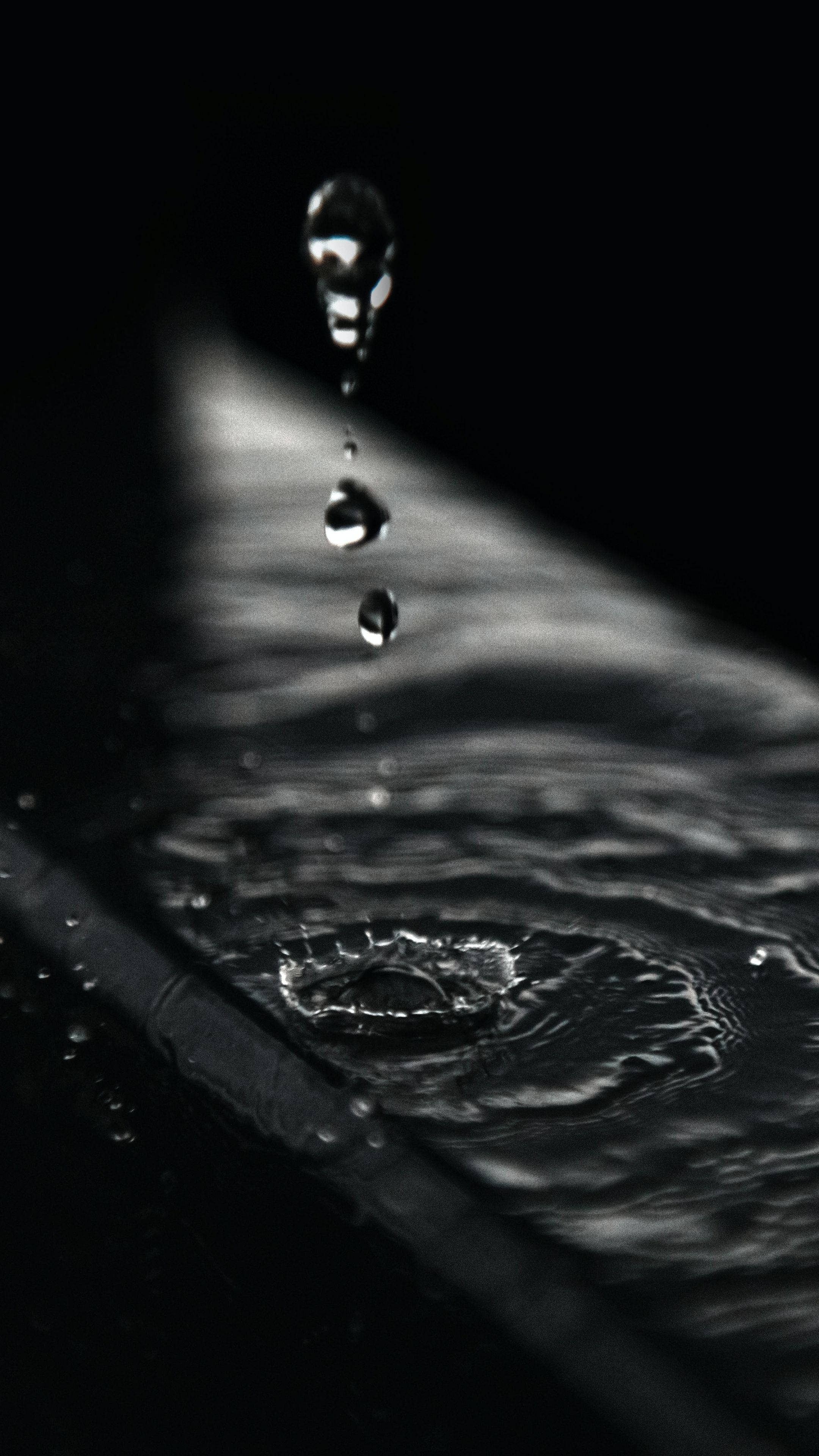 水 桌布 壁紙 — 一滴水以慢動作落在黑暗背景上，在下方表面產生漣漪。