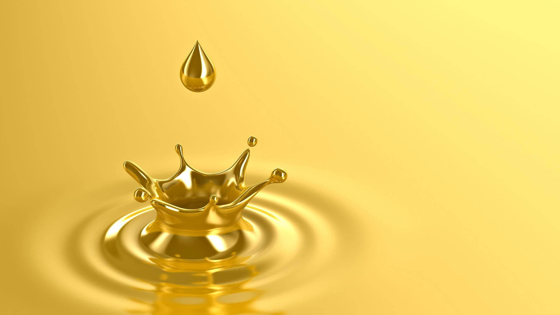 Water Drop 桌布 壁紙 — 一滴金色液體懸浮在一個皇冠形狀的水花之上，下方是光芒四射的黃色液體池。