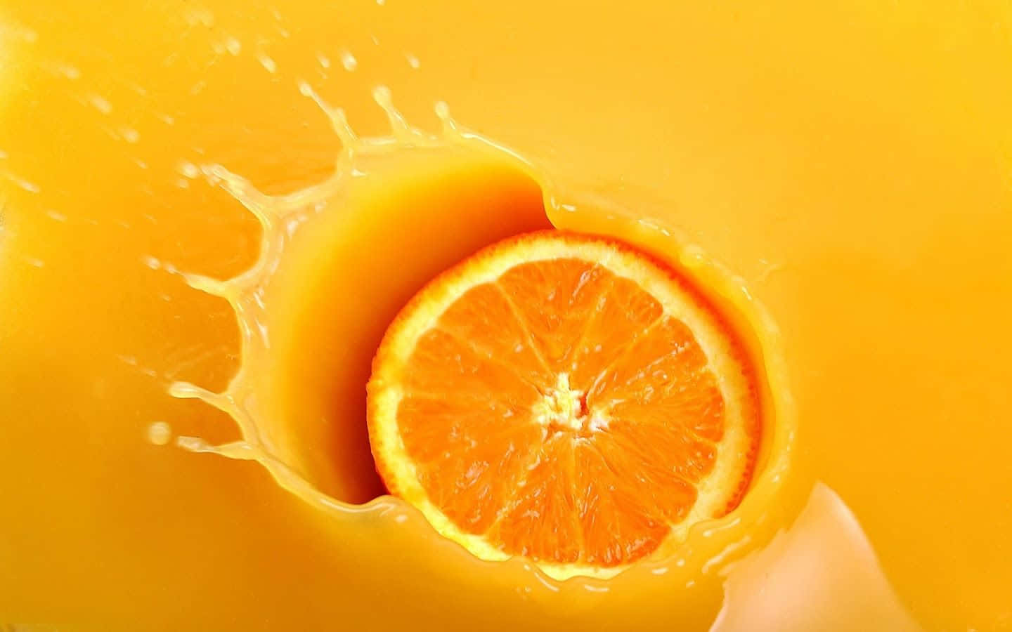 一片切開的橙子衝破橙汁飛濺。 — Juice Wrld 壁紙
