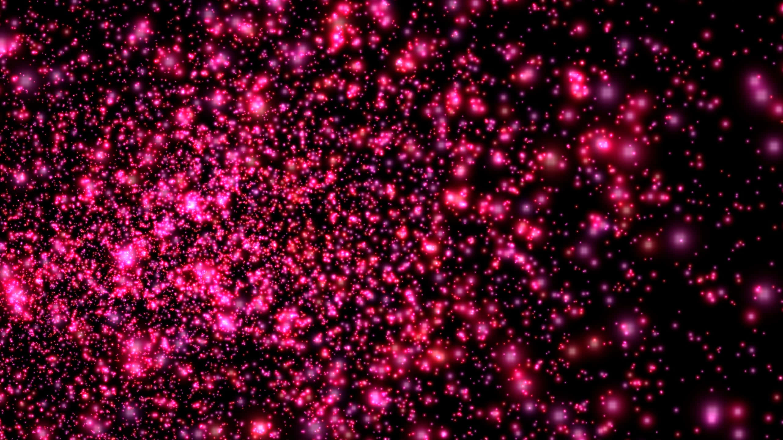 Screensavers 桌布 壁紙 — 一片充滿活力的發光粉紅色粒子像宇宙閃粉一樣飄過深邃的黑色虛空。