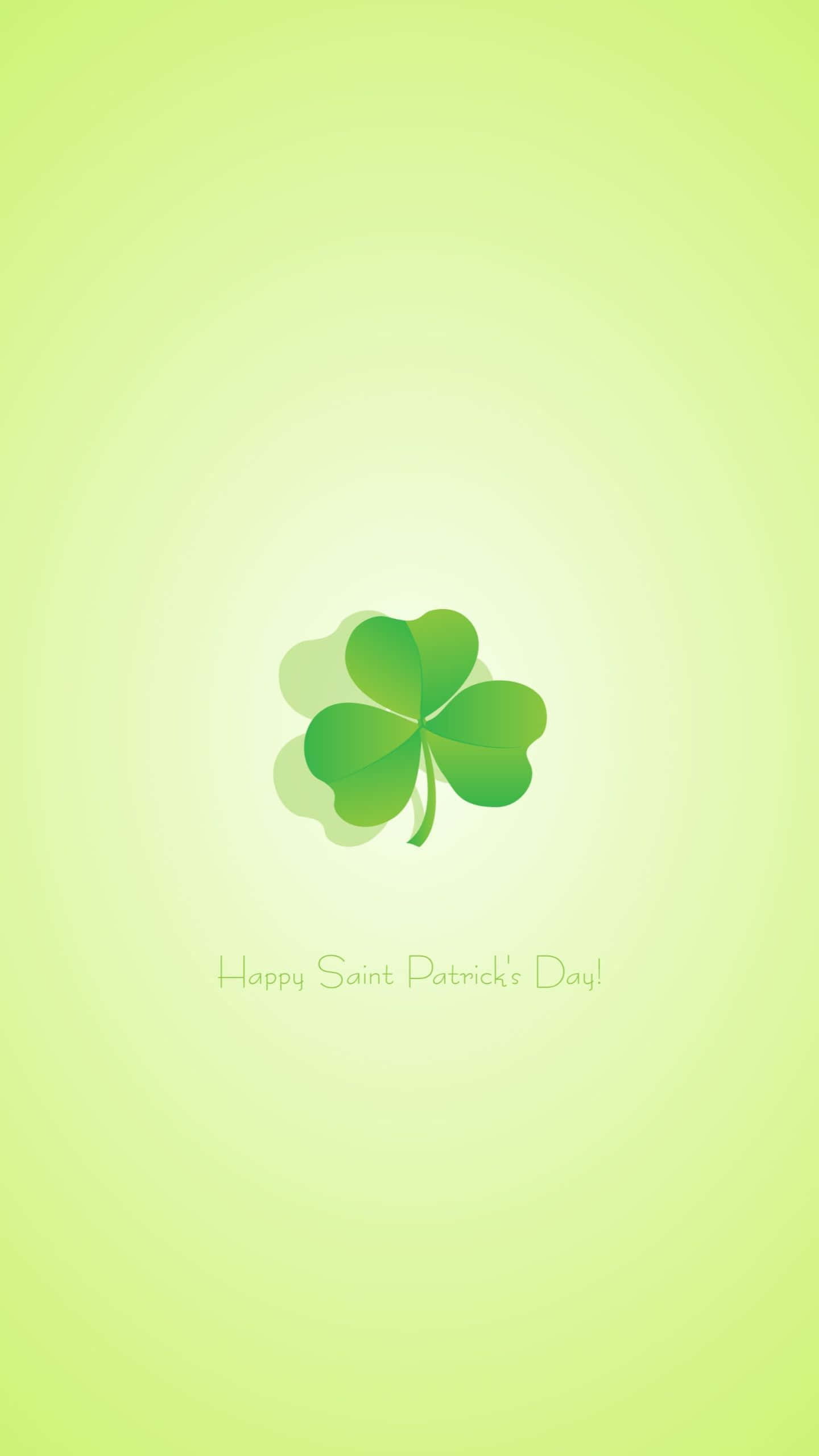 Saint Patricks Day 桌布 壁紙 — 一片充滿活力的綠色四葉草居中於柔和漸變背景上，下方有節日聖派翠克節祝福語。