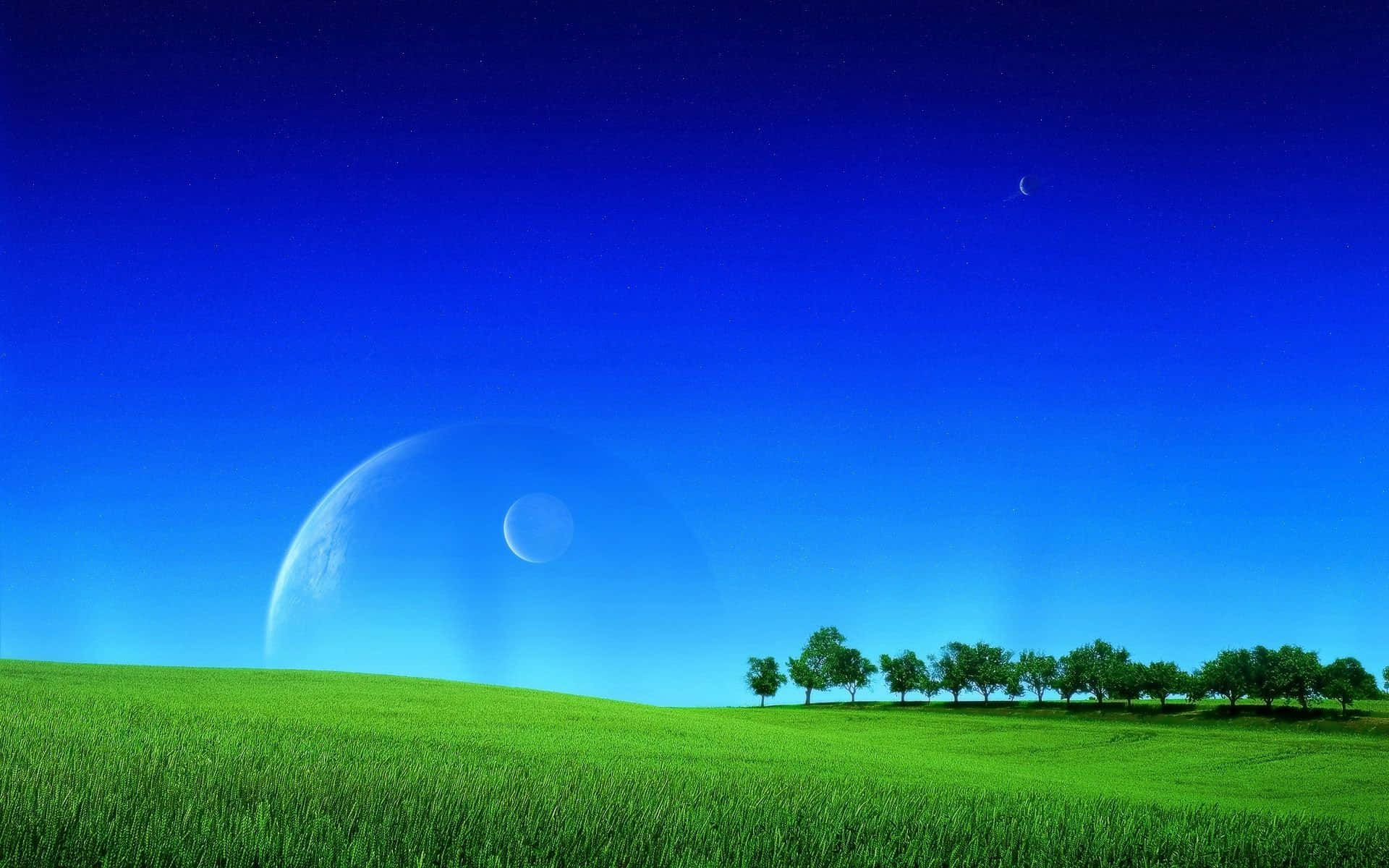 Nature Landscape 桌布 壁紙 — 一片充滿活力的綠色田野在深藍色的天空下延伸，地平線上懸掛著一彎新月和一顆巨大的行星。