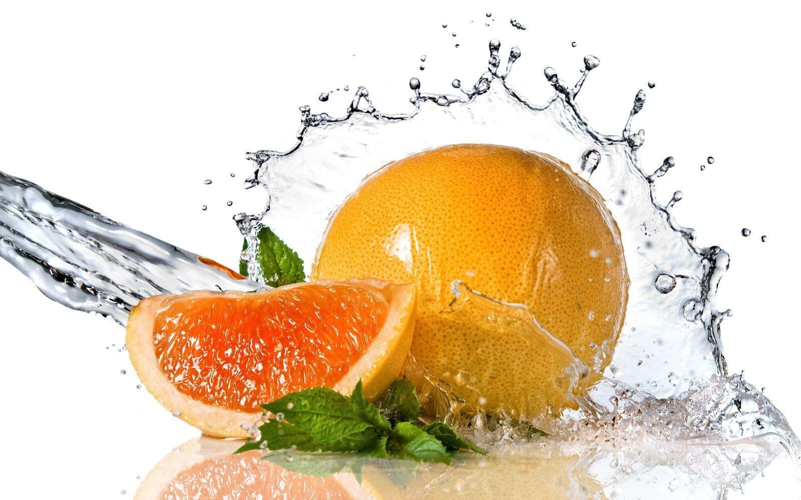 Orange Fruit 桌布 壁紙 — 一片充滿活力的葡萄柚切片和完整水果，在純白背景上迸發出動態水花。