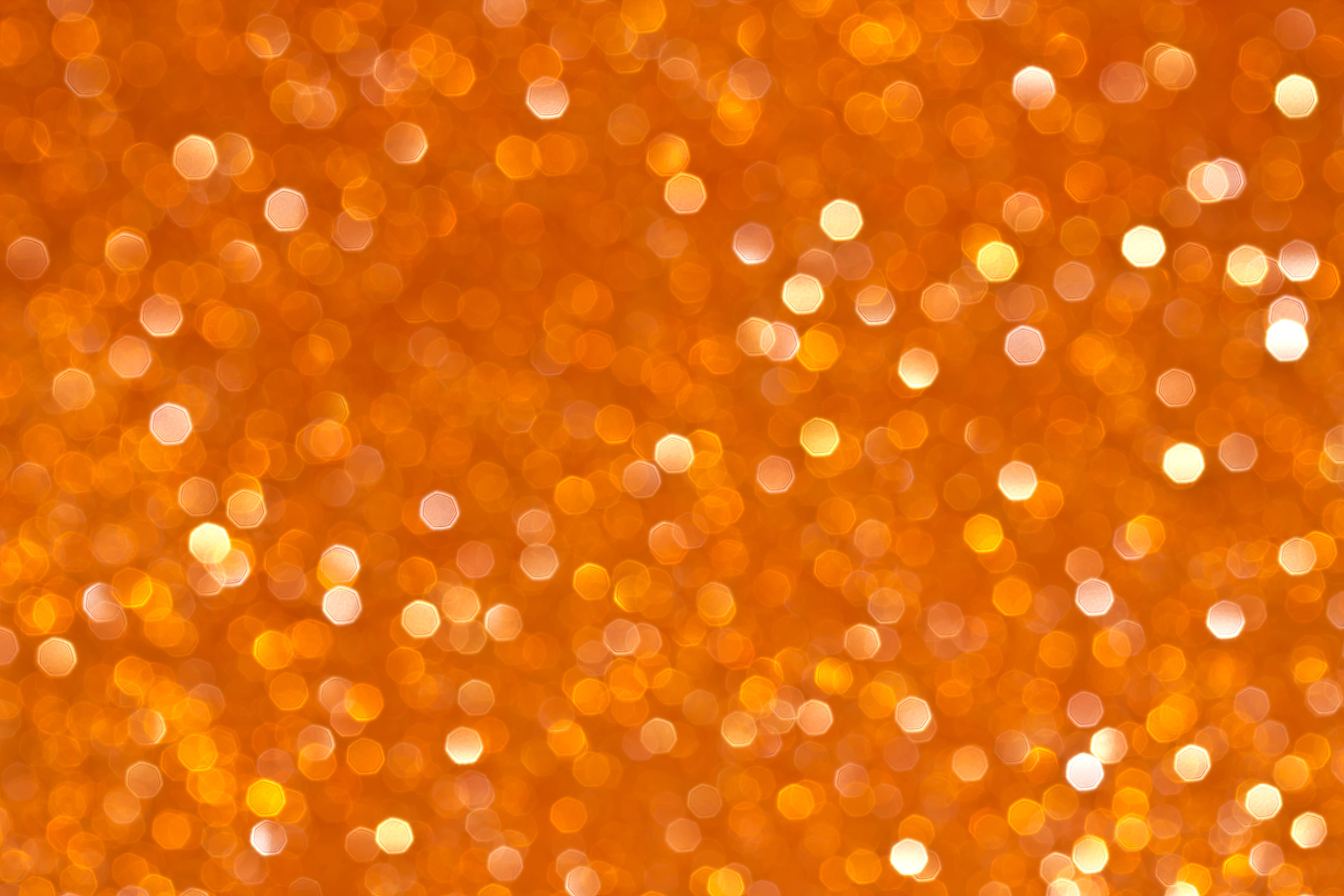 Bokeh 桌布 壁紙 — 一片充滿活力的金色散景燈光，閃爍著溫暖的橙色和黃色調。