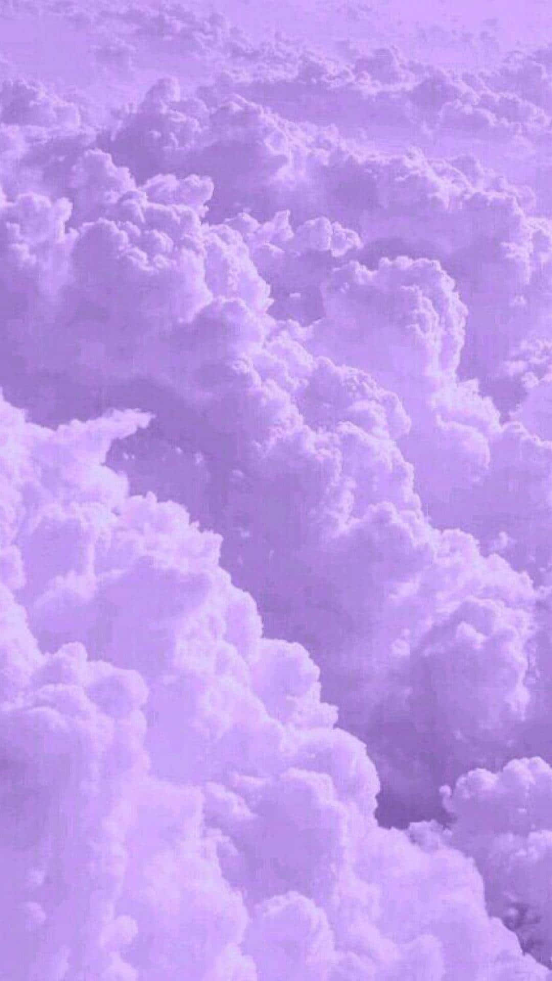 Clouds Aesthetic Tumblr 桌布 壁紙 — 一片夢幻般的蓬鬆雲朵，沐浴在柔和的薰衣草色光芒中，營造出超現實的天空場景。