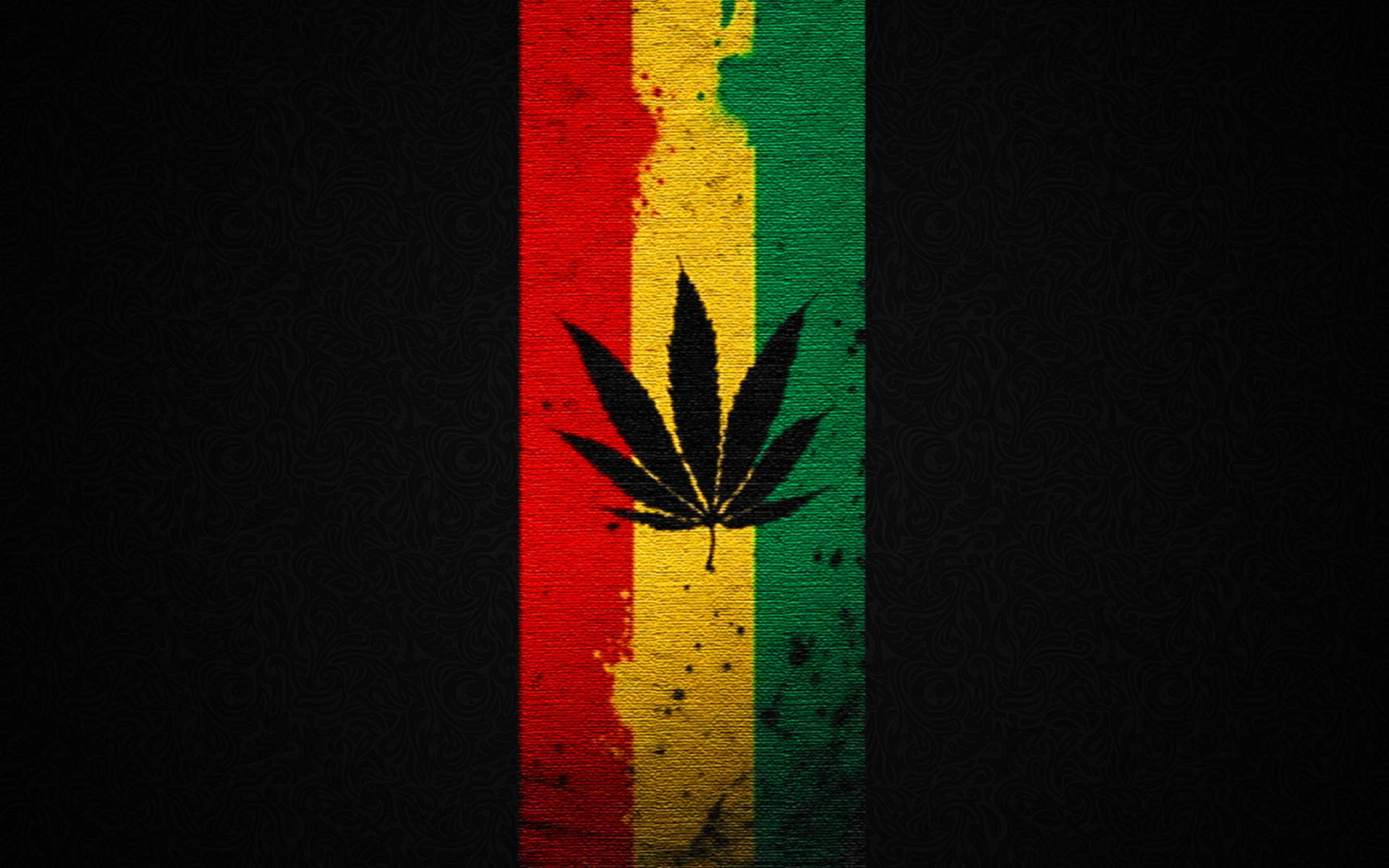 Weed Leaf 桌布 壁紙 — 一片大膽的黑色大麻葉，置於深色背景上帶紋理的紅、黃、綠垂直條紋中央。