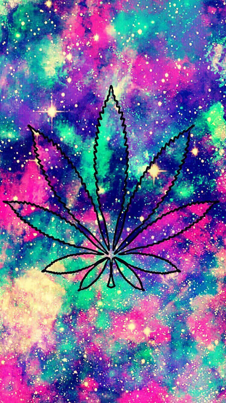Pot Leaf 桌布 壁紙 — 一片大膽黑色輪廓的大麻葉漂浮在充滿粉紅色、藍綠色和紫色星星的鮮豔宇宙星雲前。
