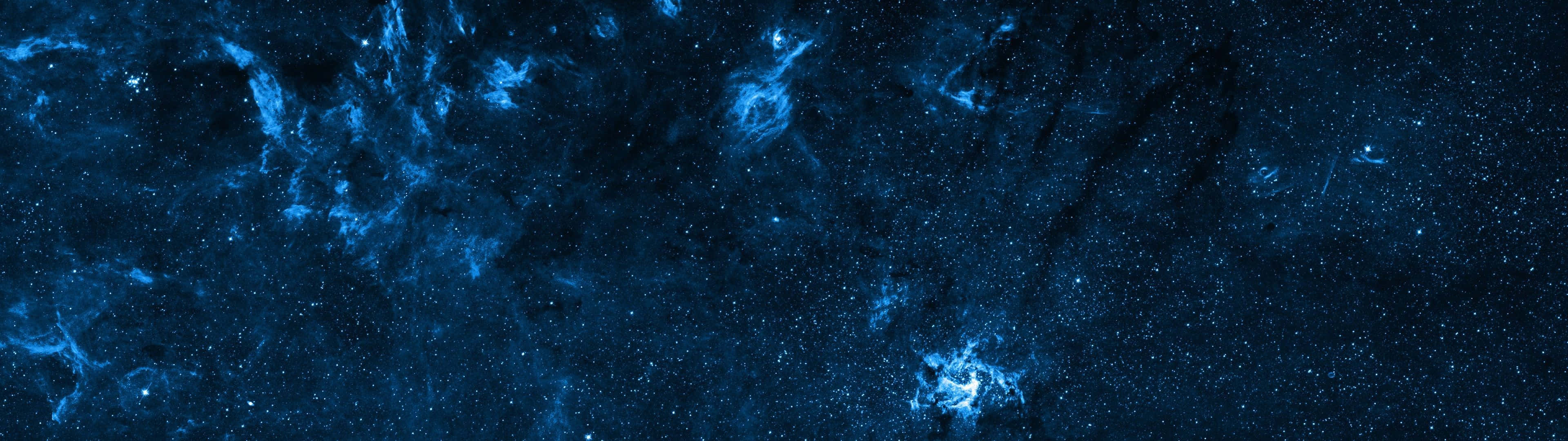 桌布 壁紙 — 一片宇宙深藍星雲和發光恆星散佈在黑暗虛空中的廣闊景象。