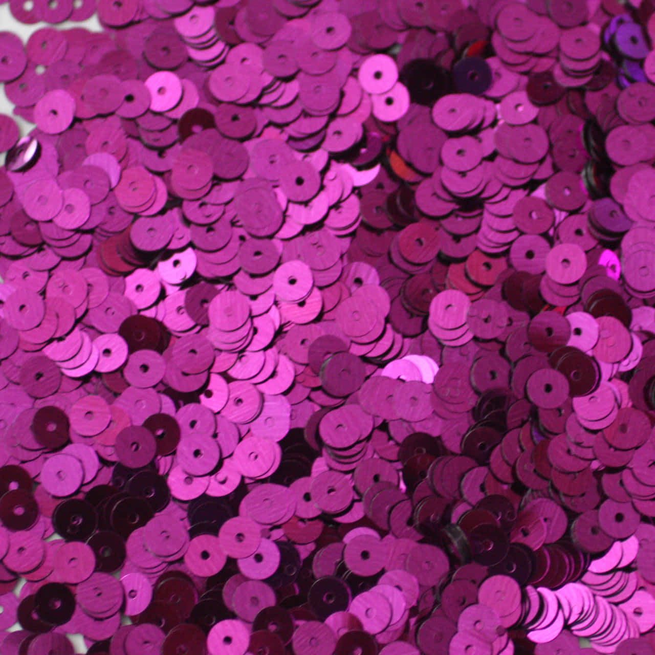 Purple Sequins 桌布 壁紙 — 一片密集的閃爍洋紅色和深紫色亮片，捕捉光線形成閃閃發光的瀑布。