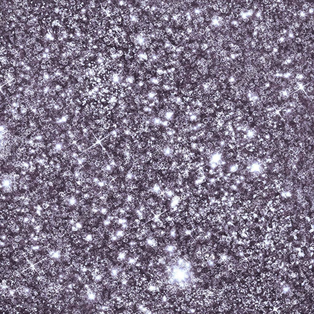 Sparkle Silver Glitter 桌布 壁紙 — 一片密集的閃爍銀色亮粉粒子在深紫色背景上捕捉光線。
