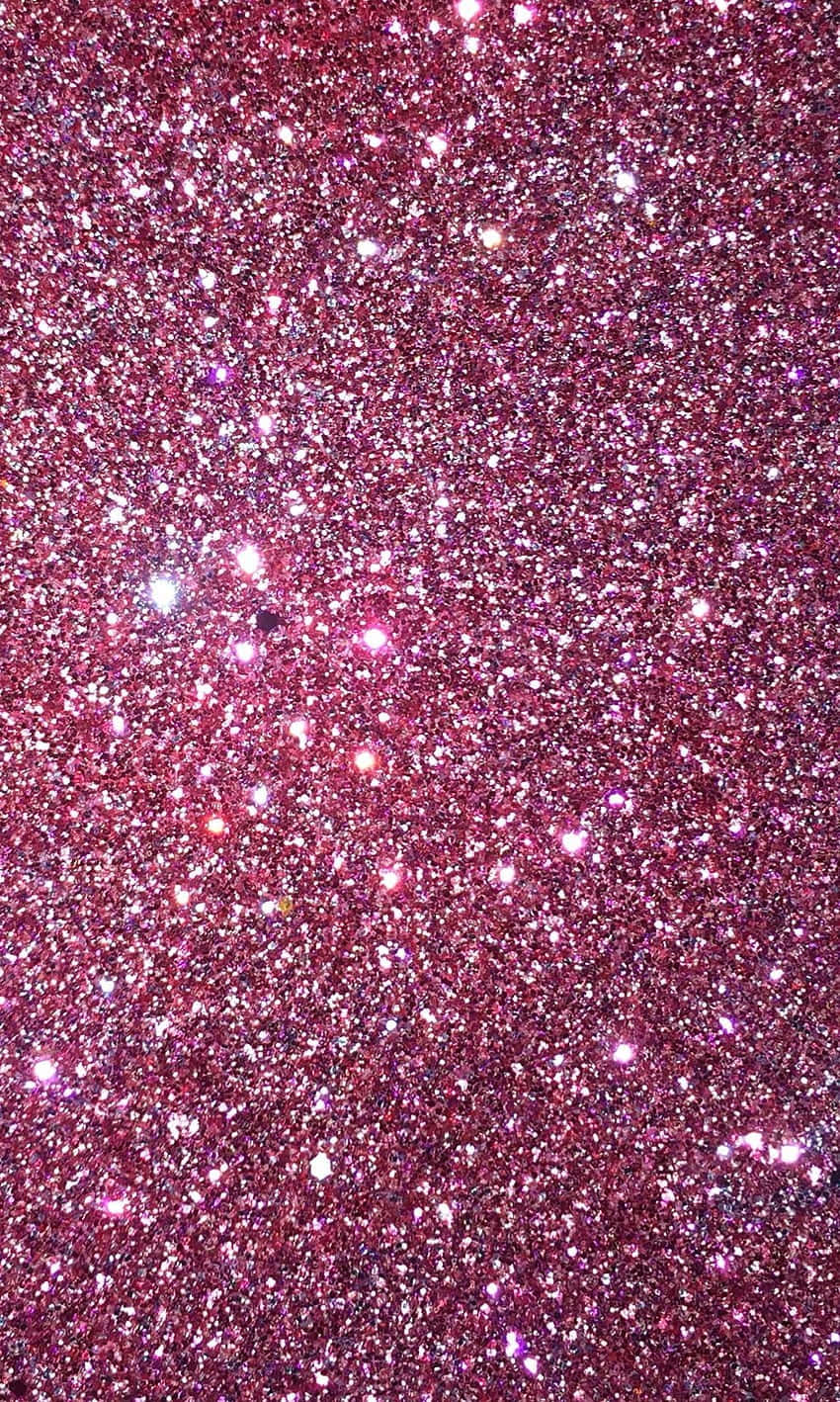 Pink Sparkly 桌布 壁紙 — 一片密集閃爍的粉紅色亮粉，帶有明亮的反射高光，在表面閃爍。