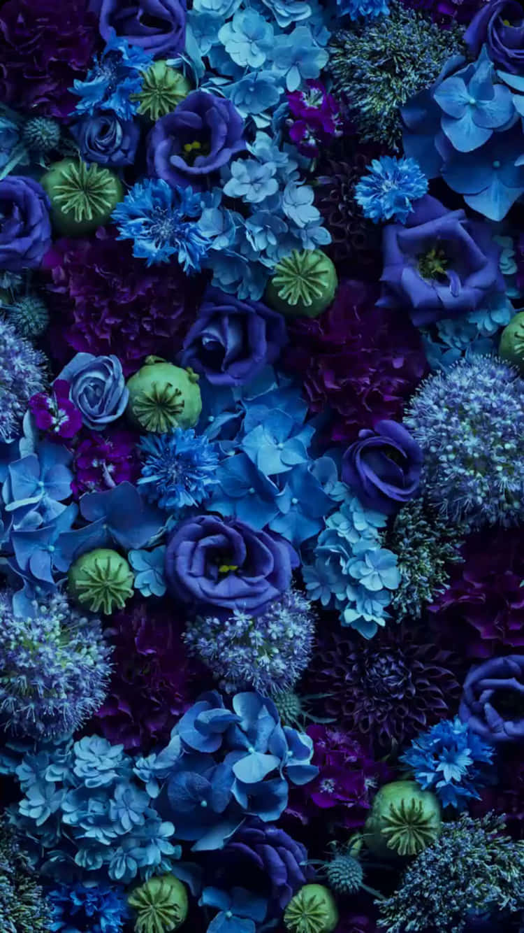 Blue Flowers Aesthetic 桌布 壁紙 — 一片密集鮮豔的藍色和紫色花朵牆，帶有綠色點綴，色調豐富飽和。