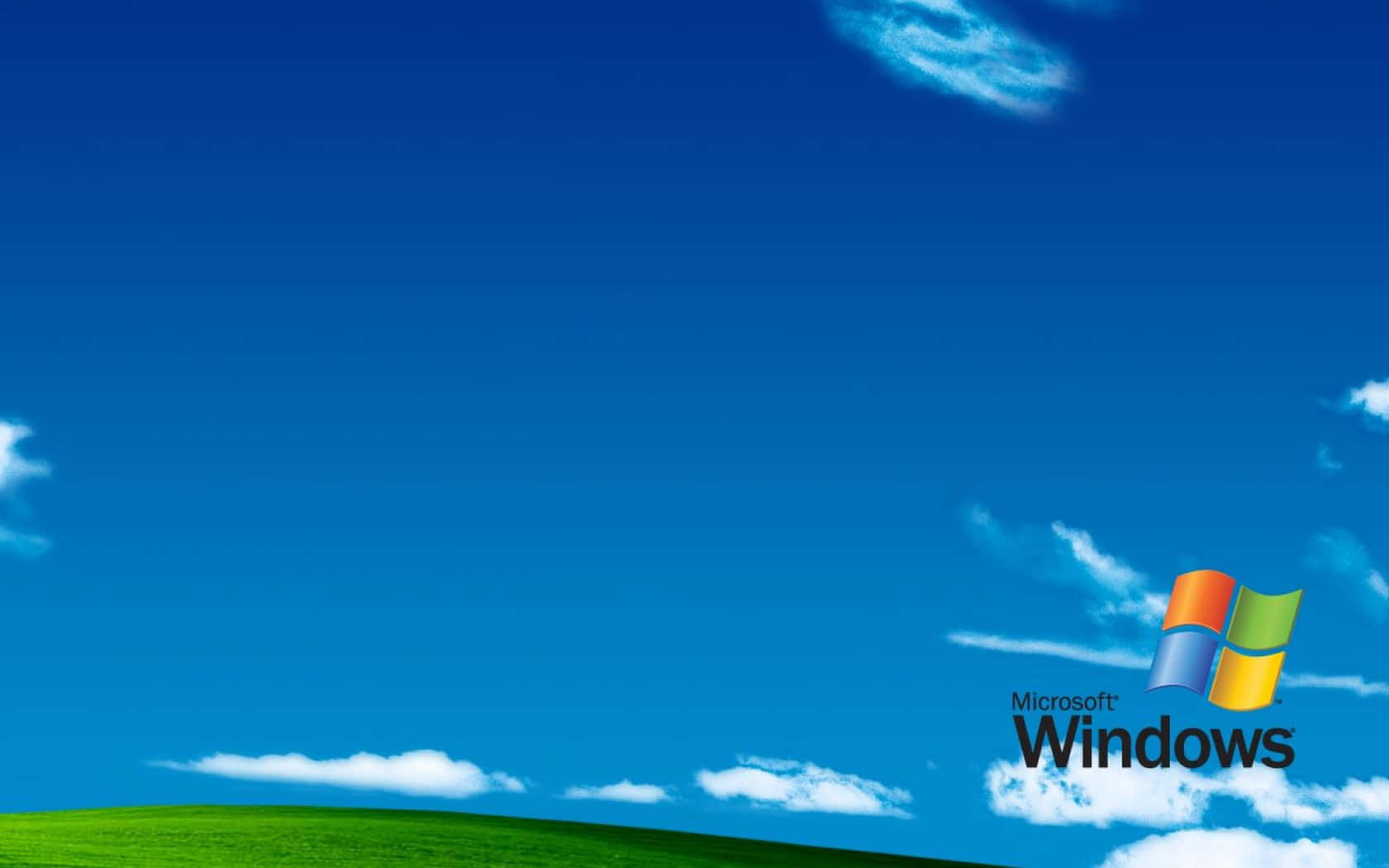 帶有 Microsoft Windows 標誌的藍天下綠色山丘