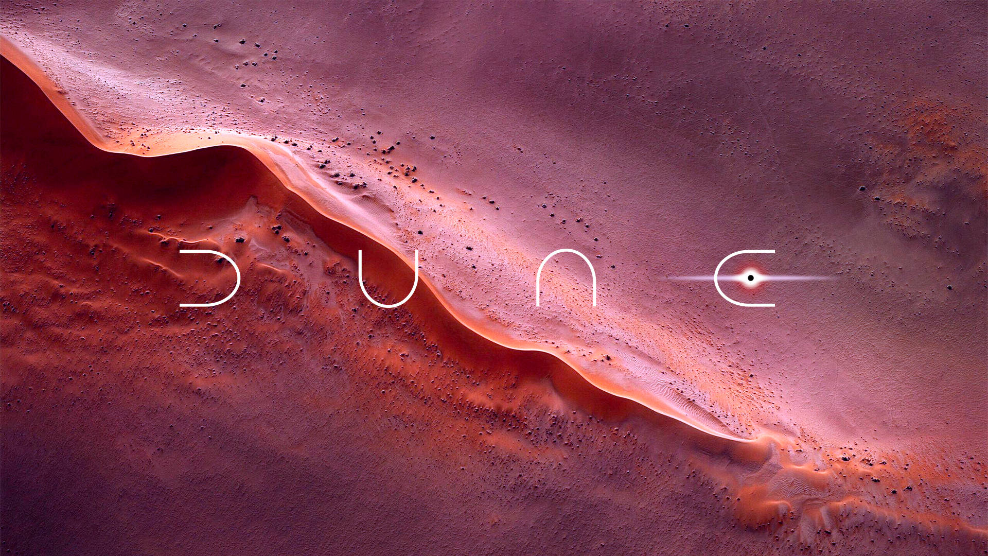 Dune 2021 桌布 壁紙 — 一片廣闊的沙漠沙丘，帶有發光的橙色山脊，沙地上以極簡白色字體寫著「DUNE」一詞。