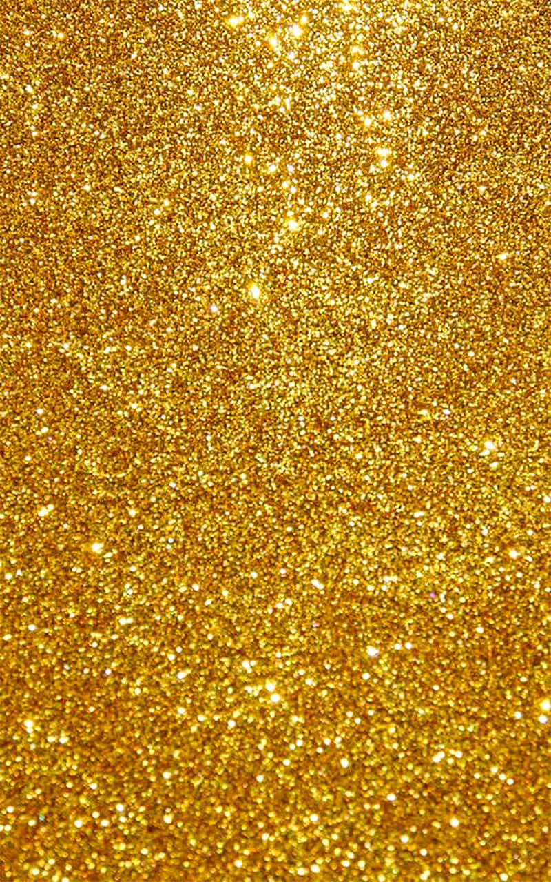 Yellow Glitter 桌布 壁紙 — 一片閃耀的金色亮粉場地，在明亮光線下閃爍著無數閃亮粒子。