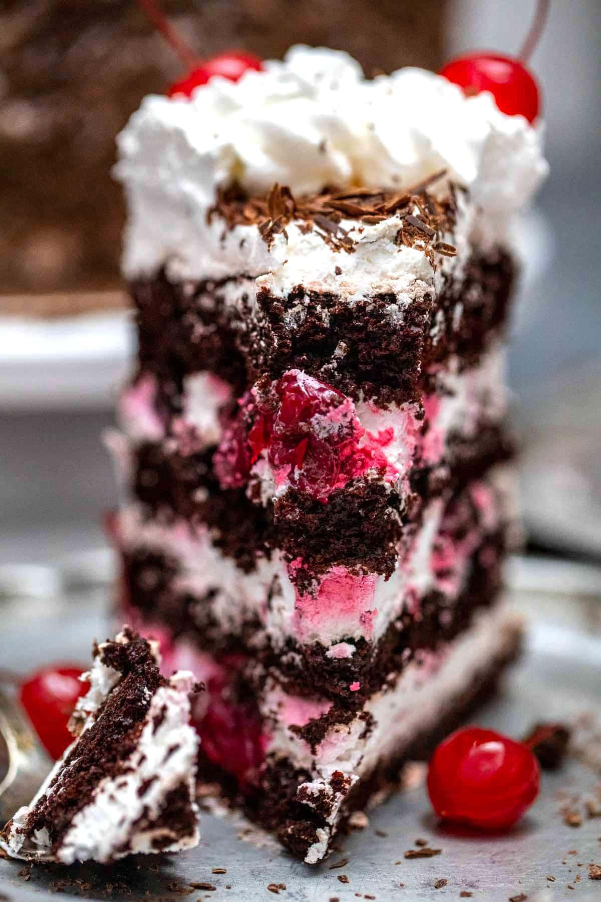 Black Forest Cake 桌布 壁紙 — 一片頹廢的黑櫻桃蛋糕，上面有鮮奶油和黑櫻桃。