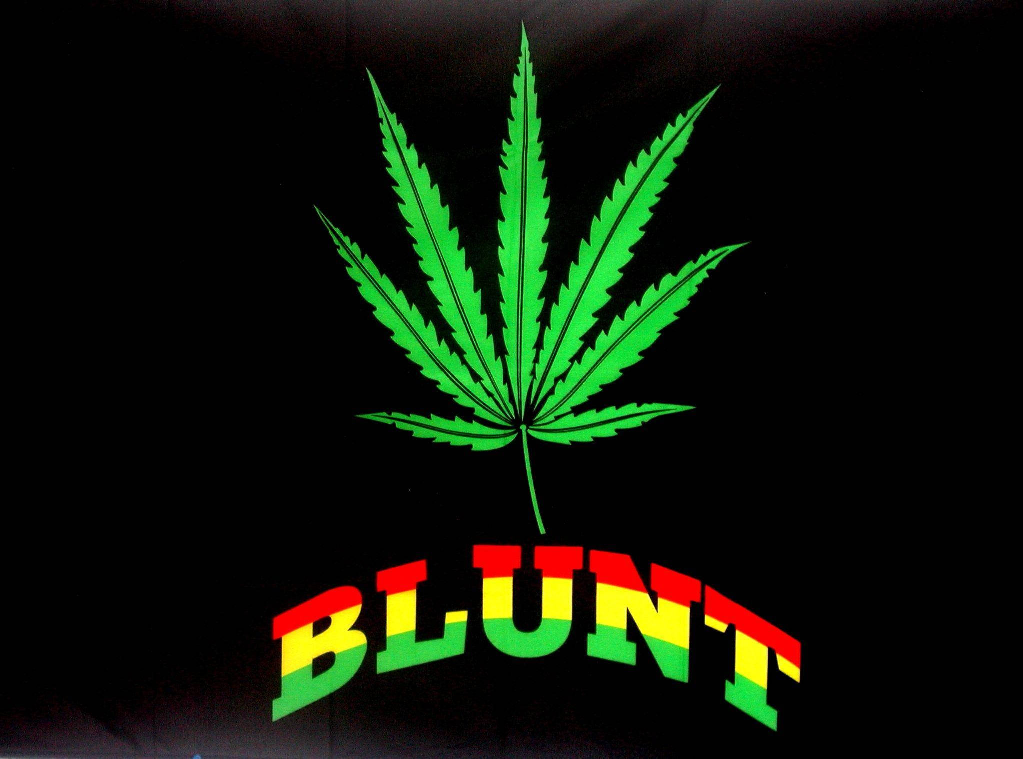 Blunt 桌布 壁紙 — 一片鮮綠色的大麻葉，上面有紅、黃、綠色的「BLUNT」字樣，背景為黑色。