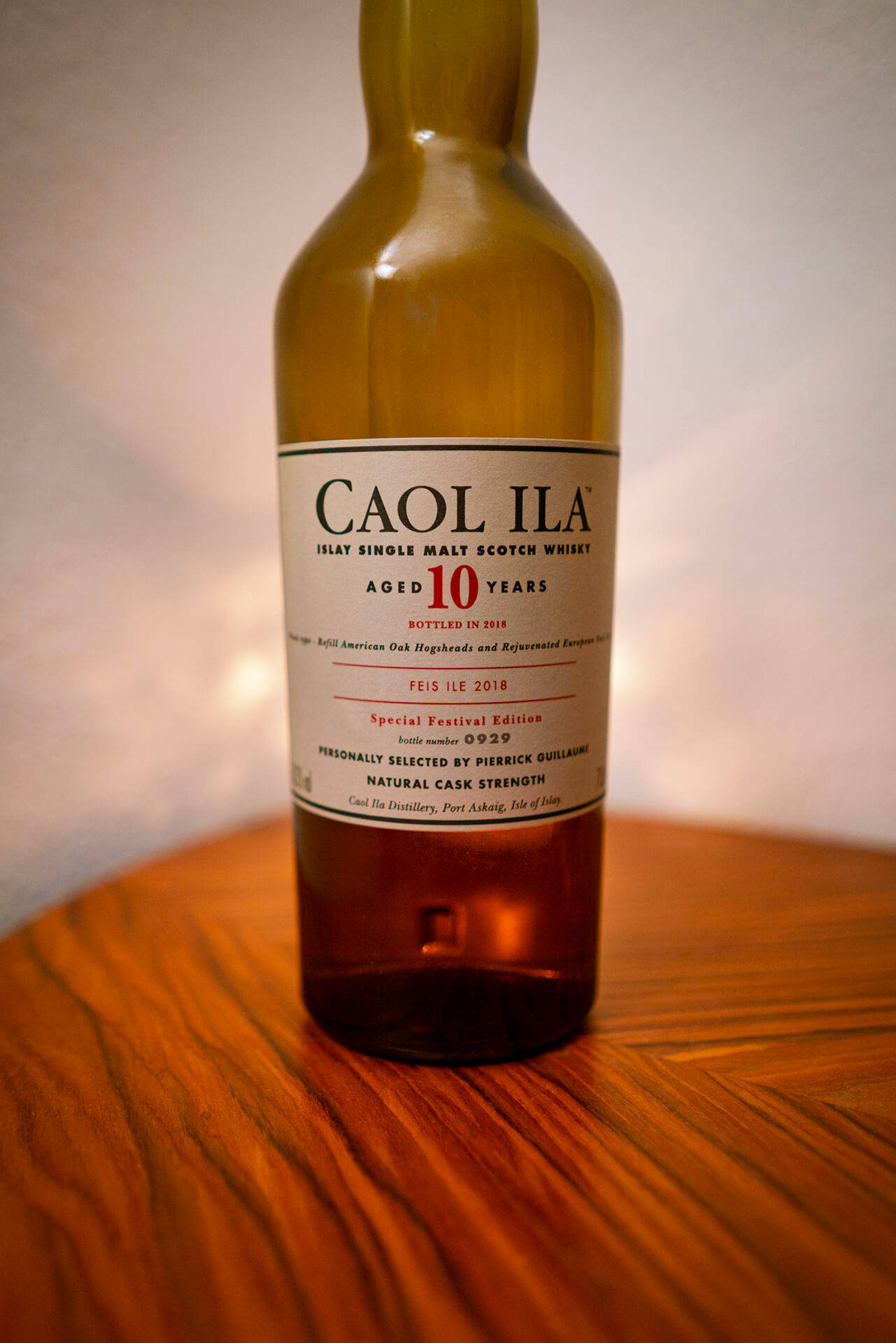 alcohol 桌布 壁紙 — 一瓶 Caol Ila 10 年單一麥芽蘇格蘭威士忌放在溫暖的木桌上，光線柔和。