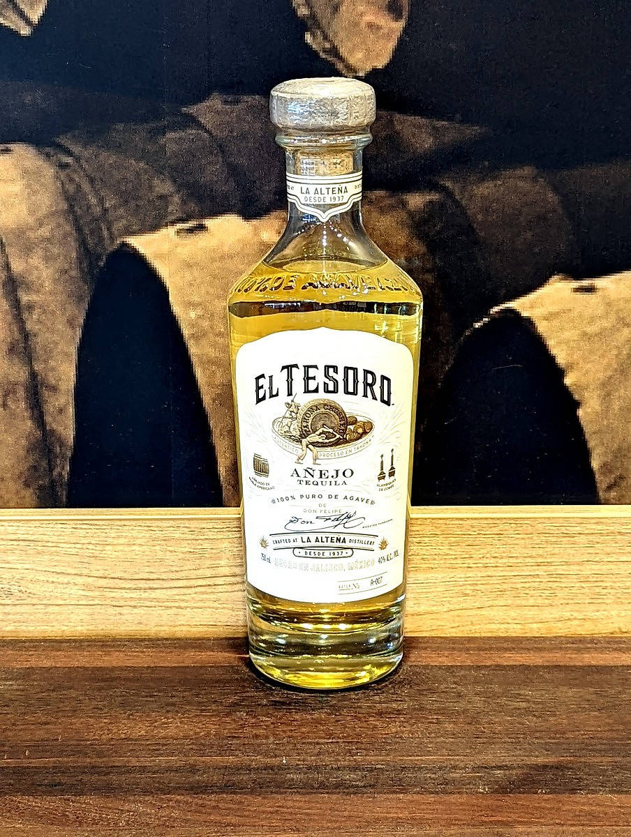 bottle 桌布 壁紙 — 一瓶 El Tesoro Añejo 龍舌蘭酒放置在帶有深色紋理背景的木質表面上。