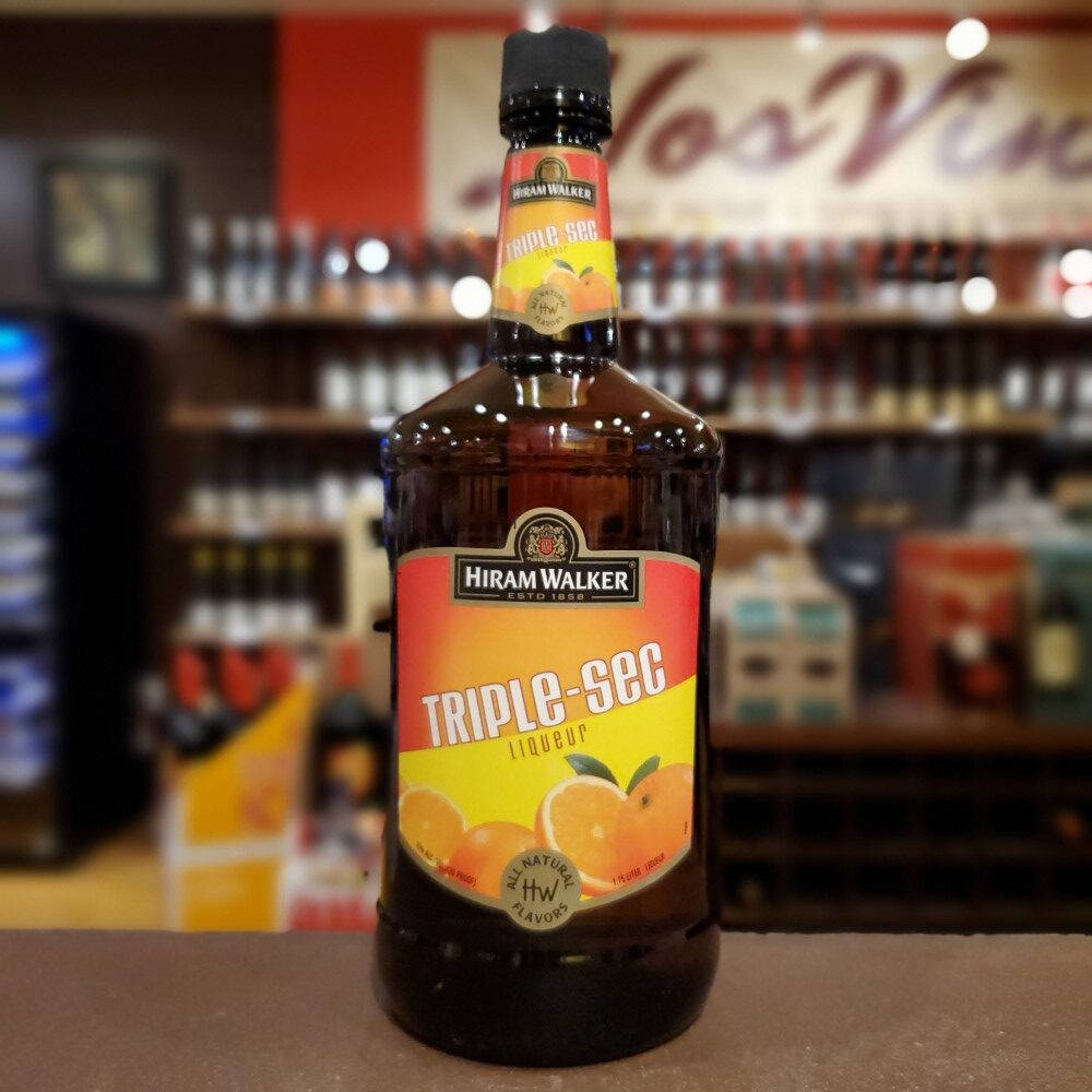 alcohol 桌布 壁紙 — 一瓶 Hiram Walker Triple Sec 利口酒醒目地放在商店櫃檯上，背景是模糊的酒架。