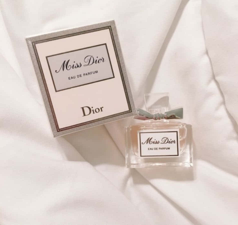 Miss Dior 香水瓶及盒子在白色布料上 — Dior 動態 壁紙