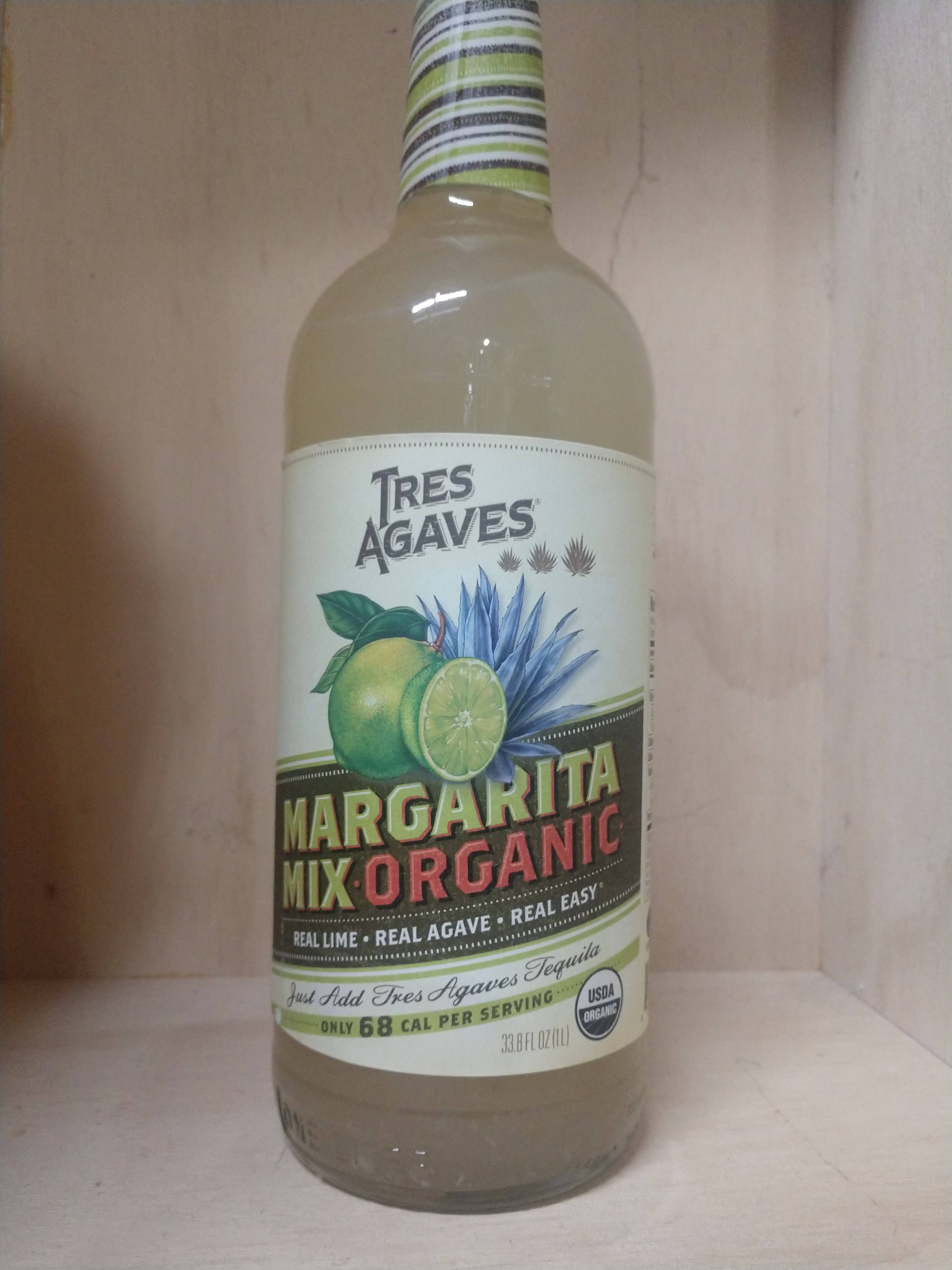 drinks 桌布 壁紙 — 一瓶 Tres Agaves Margarita Mix Organic 放在木架上，帶有條紋蓋和青檸龍舌蘭圖案。