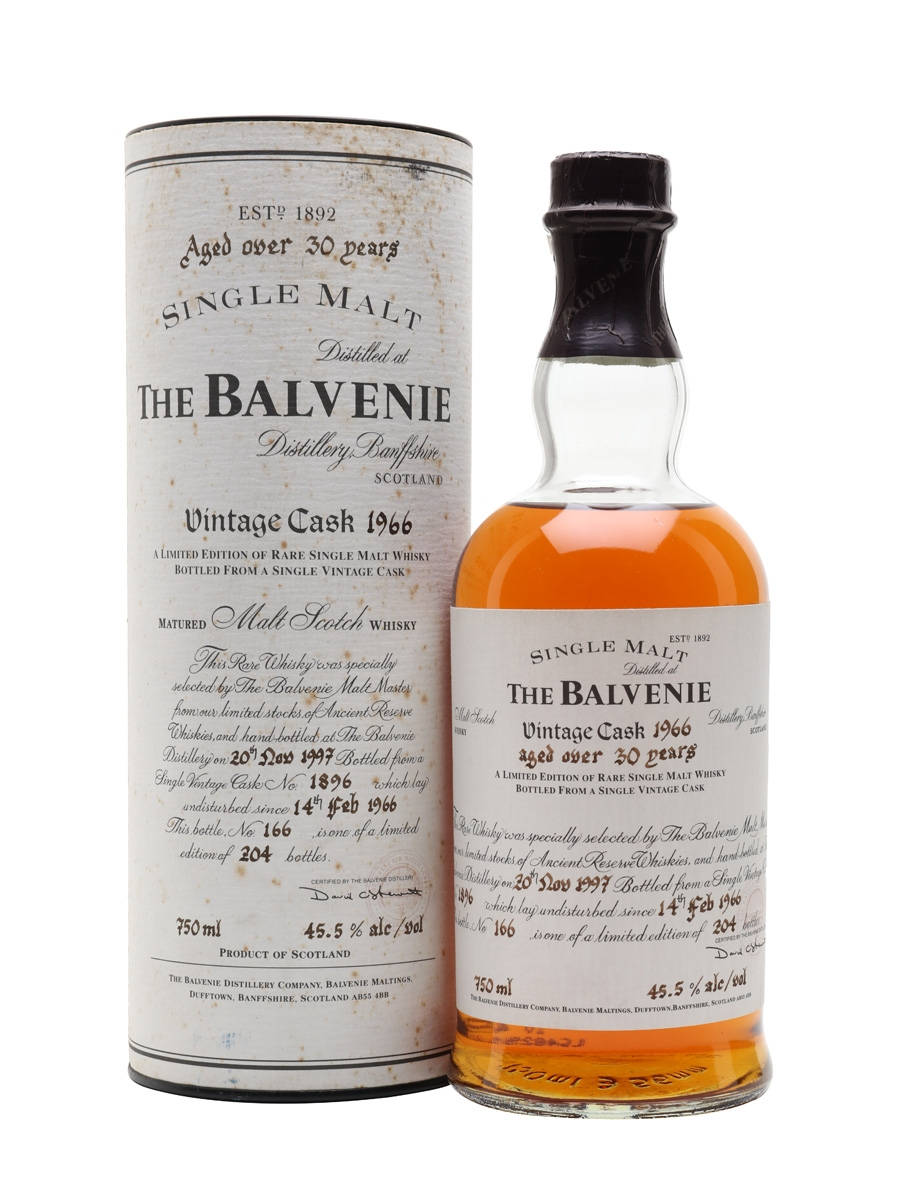 飲料 桌布 壁紙 — 一瓶1966年復古The Balvenie單一麥芽威士忌及其圓柱形禮盒，在潔白背景上展示陳年琥珀色液體和優雅字體。