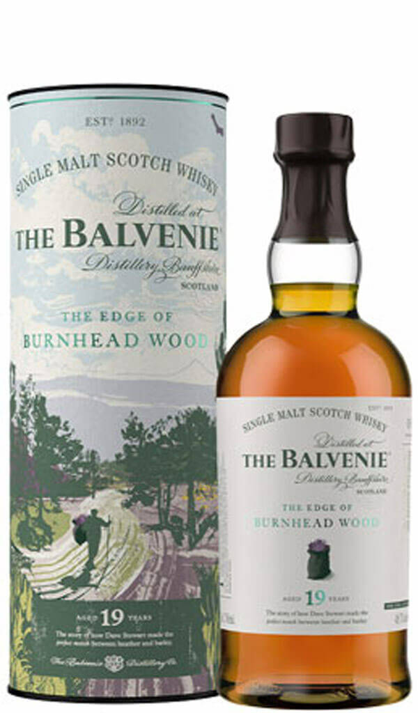 Drink 桌布 壁紙 — 一瓶19年陳釀的The Balvenie單一麥芽蘇格蘭威士忌，旁邊是其帶有插圖的圓柱形禮盒，圖案為Burnhead Wood附近的遠足者。