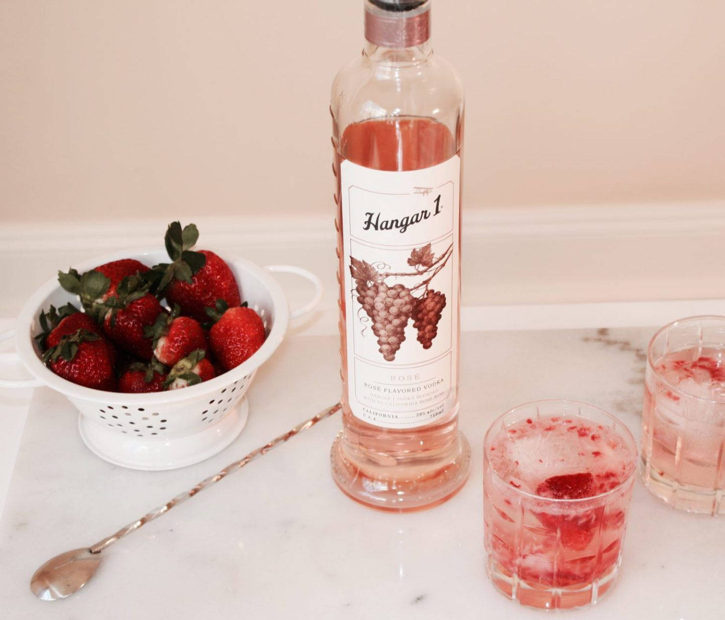 cocktail 桌布 壁紙 — 一瓶Hangar 1 Rosé Vodka與新鮮草莓和兩杯草莓雞尾酒放在大理石檯面上。