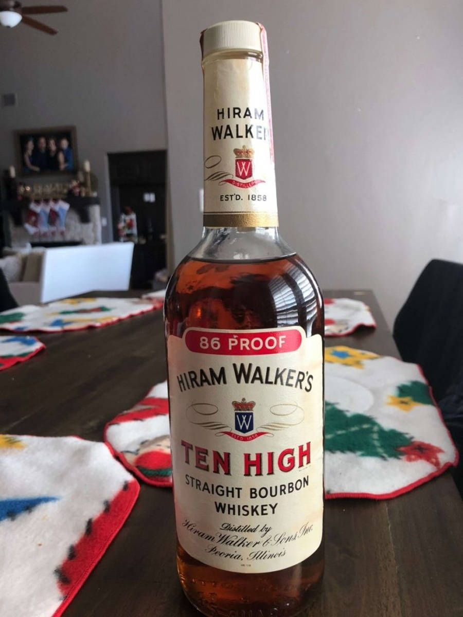 alcohol 桌布 壁紙 — 一瓶Hiram Walker's Ten High Straight Bourbon Whiskey放在深色木桌中央，周圍是節日主題的餐墊。